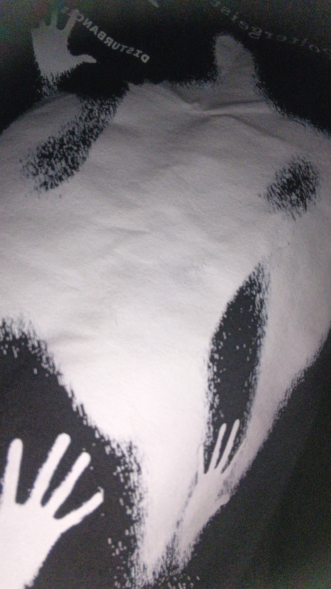 The image depicts a dark background with a scattering of white powder, possibly flour or sugar. A silhouette of a human torso is visible, formed by the absence of powder on the surface. There are two handprints clearly impressed in the powder on the lower left and right sides of the image. In the upper portion of the image, text is visible, mirrored and reversed, reading "DISTURBANCE". The scene does not provide any specific geographical indicators to determine its location within Banjarmasin, Indonesia.