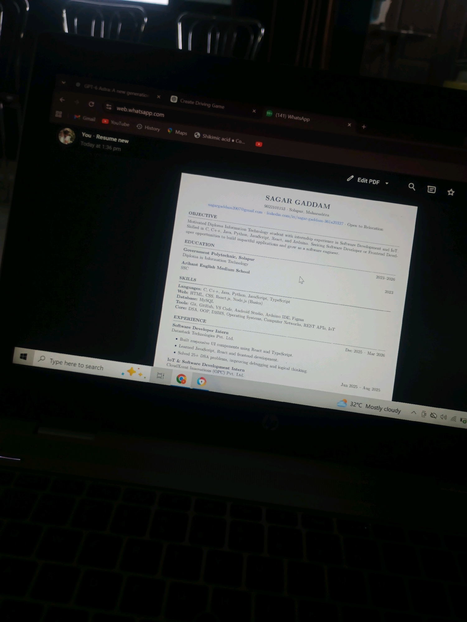 The image displays a laptop screen showing a resume. The resume is for Sagar Gaddam and includes sections for Objective, Education, Skills, and Experience. The location is specified as Solapur, Maharashtra, India. The screen also shows a web browser with tabs for WhatsApp and other websites, and the Windows taskbar at the bottom. A partial view of the keyboard is visible.