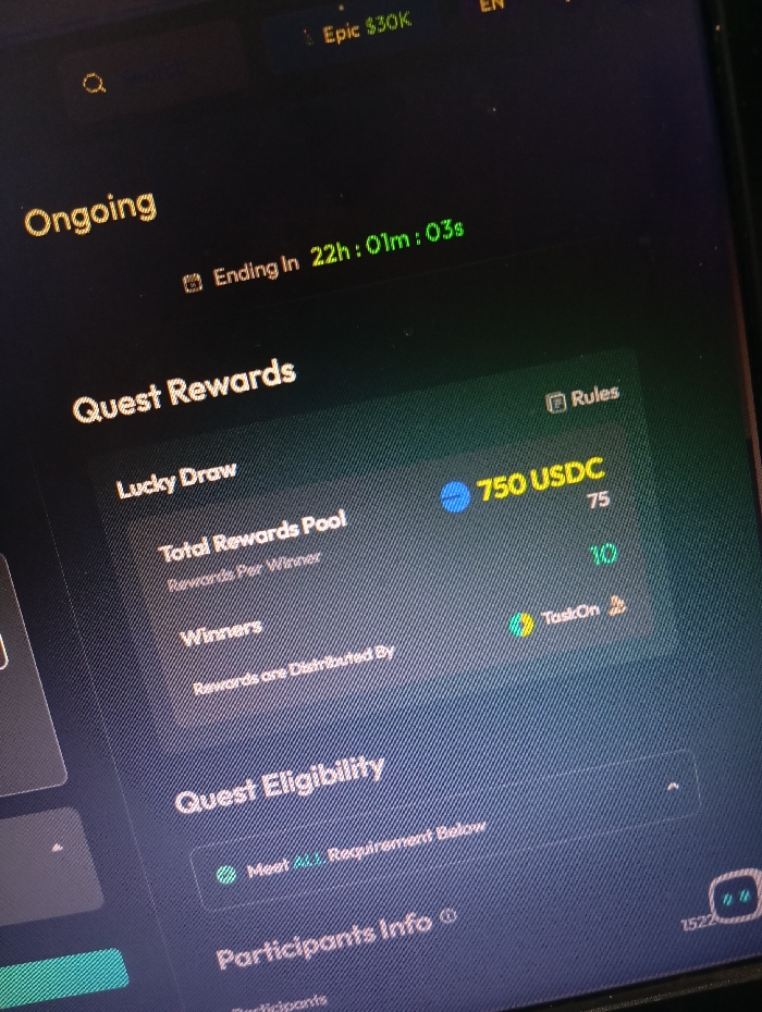 A computer screen displays a dark background with green and yellow text and icons. The words "Ongoing" and "Quest Rewards" are at the top in a yellow font. The words "Lucky Draw" and "Total Rewards Pool" are present, along with a description for "Rewards Per Winner." Below that is "Winners" with "Rewards are Distributed By." The text "Quest Eligibility" appears, with "Meet All Requirements Below." Below that is "Participants Info" with a small icon. The text "Ending in 22h:01m:03s" is visible in a green font. The number "750 USDC" is in a blue circle, with a text box next to it containing "Rules" and "Task On." There is also the number "10" and "75" visible. This appears to be a screenshot of an app on a computer. The image was taken on a computer screen in the city of Temanggung, Indonesia.