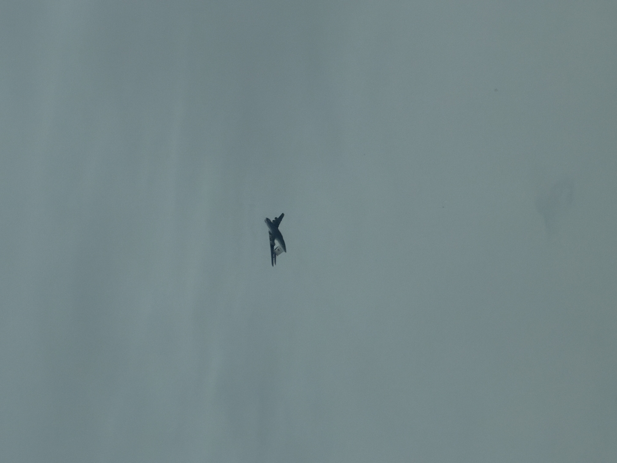 A military jet aircraft is flying against an overcast sky. The location, Kosoturikha, Russia, is not discernible from the image.
