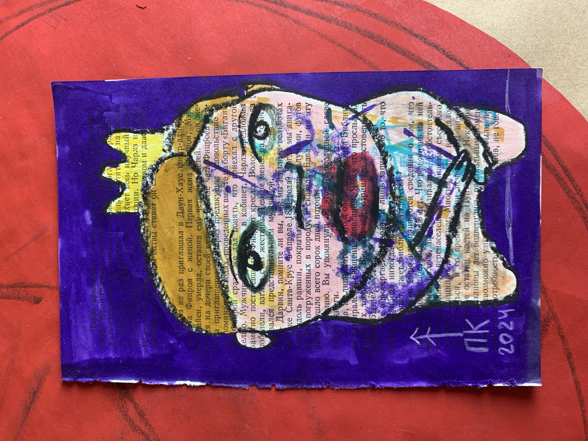 The image shows a piece of paper with text and drawings on it, placed on a red textured surface. The paper itself appears to be from a book, with printed text in Russian. The text is partially obscured by purple and yellow marker drawings.
The drawings depict a stylized, somewhat abstract representation of a head and shoulders, with a crown-like element on top. The colors used are purple, yellow, white, black, and a touch of pink. The drawing has a somewhat childlike or folk art aesthetic.
Visible text includes Russian words and phrases, as well as numbers. Notably, "2024" is clearly visible on the bottom right of the paper, likely indicating the year. There are also symbols and what appears to be a rudimentary arrow drawn in white.
The overall impression is that of a handmade postcard or a collage. The book page background suggests a theme related to the text, possibly history or science, given the presence of words like "Чарлз" (Charles), "Даун-Хаус" (Down House), "Дарвин" (Darwin), and "Библия" (Bible). The red textured surface could be a table or a wall.