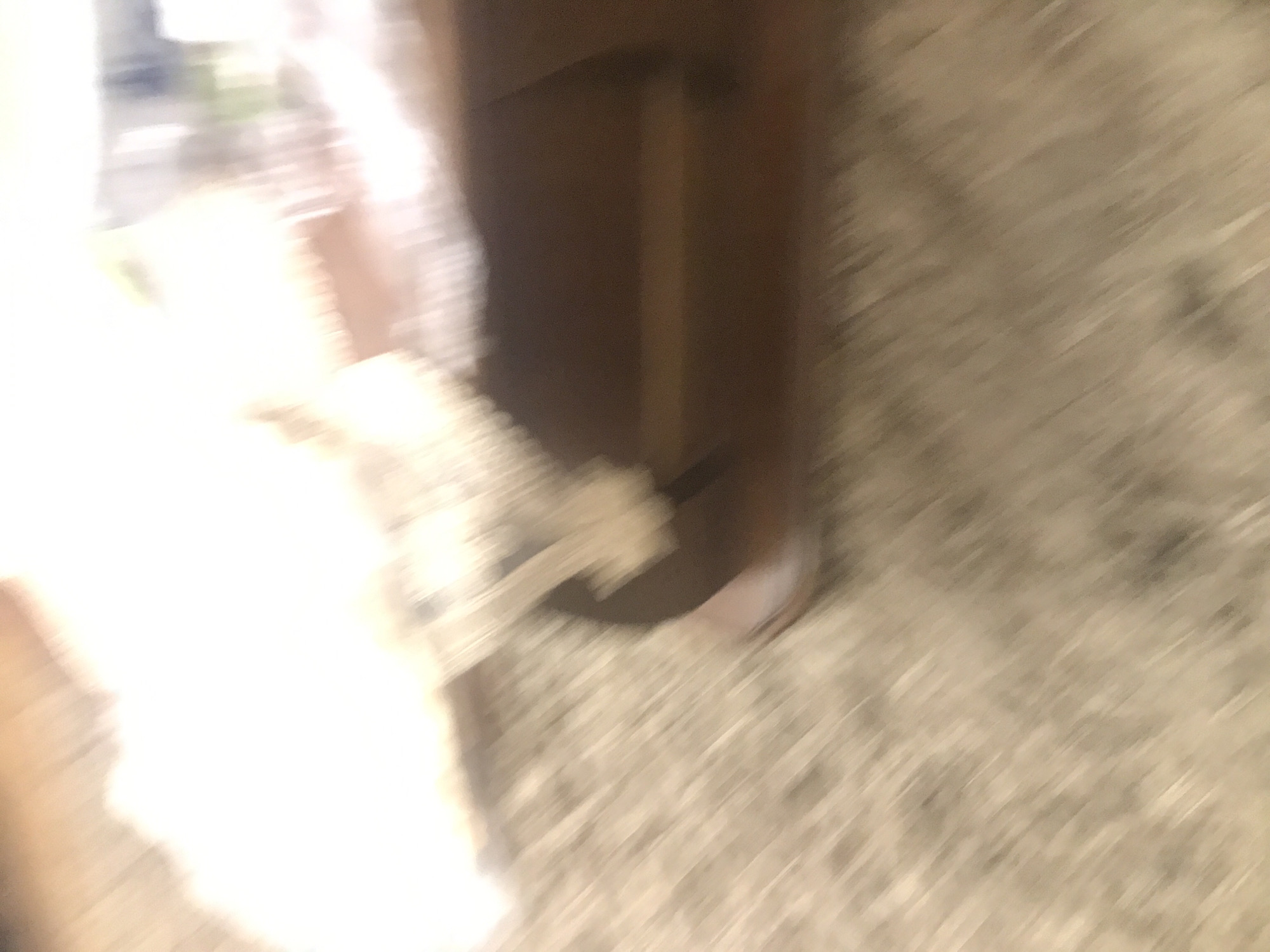 The image shows a blurry scene, possibly an interior. There is a brown wooden object, which could be a piece of furniture, and a light-colored surface, potentially a rug or carpet. Due to the blur, specific details like people or exact objects are indistinct. There is no information in the image to indicate that it is in Yerevan, Armenia.