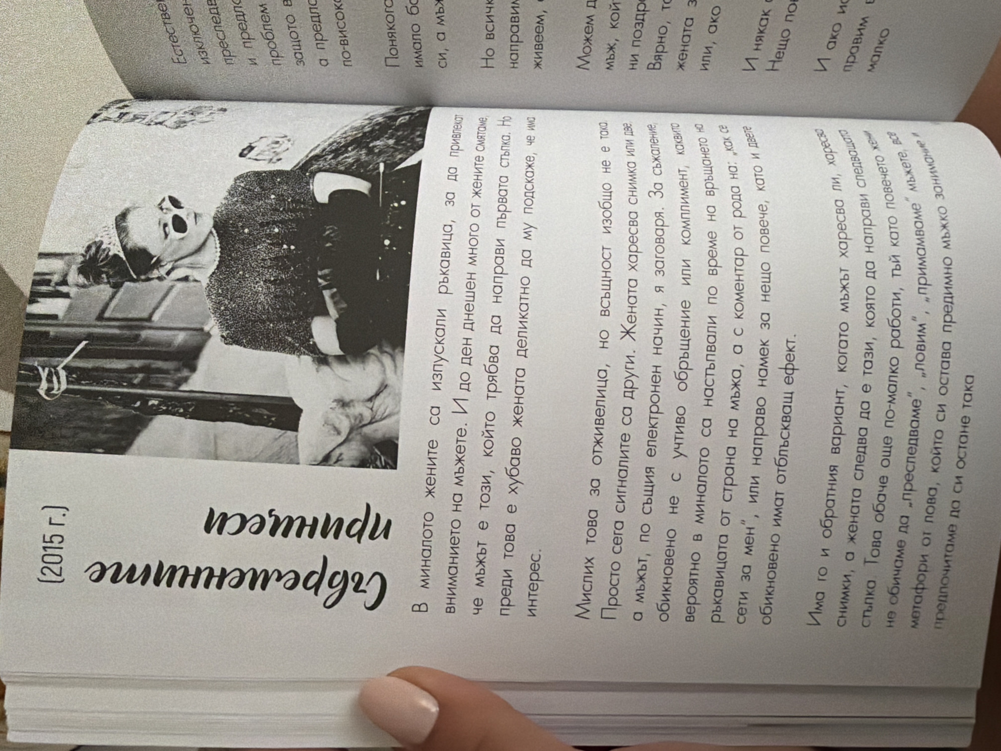 The image is a close-up photograph of an open book, focusing on a page with text and a black and white photograph. The book appears to be a magazine or a collection of essays, with a contemporary style. The photograph shows a woman with her hair styled in a bun, wearing sunglasses and a tiara, suggesting a fashion or artistic theme. She is looking to the side with a confident expression. The text on the page is in Bulgarian and discusses relationships and social cues between men and women. There are no discernible landmarks or elements within the image that would allow for the identification of a specific location in Pazardzhik, Bulgaria. The scene is entirely contained within the book itself.