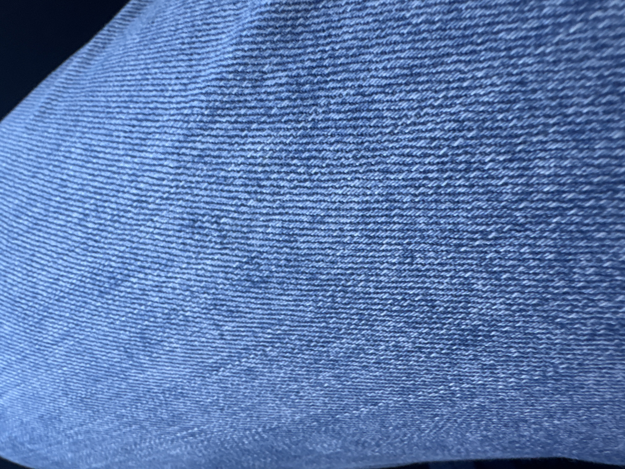 The image shows a close-up of blue denim fabric. The weave of the fabric is visible, with horizontal lines of the weft threads running across the image. The color of the denim is a medium blue with some lighter shades. The fabric appears slightly textured and soft. There is no indication of Strazha, Bulgaria, people, objects, or actions in this image.