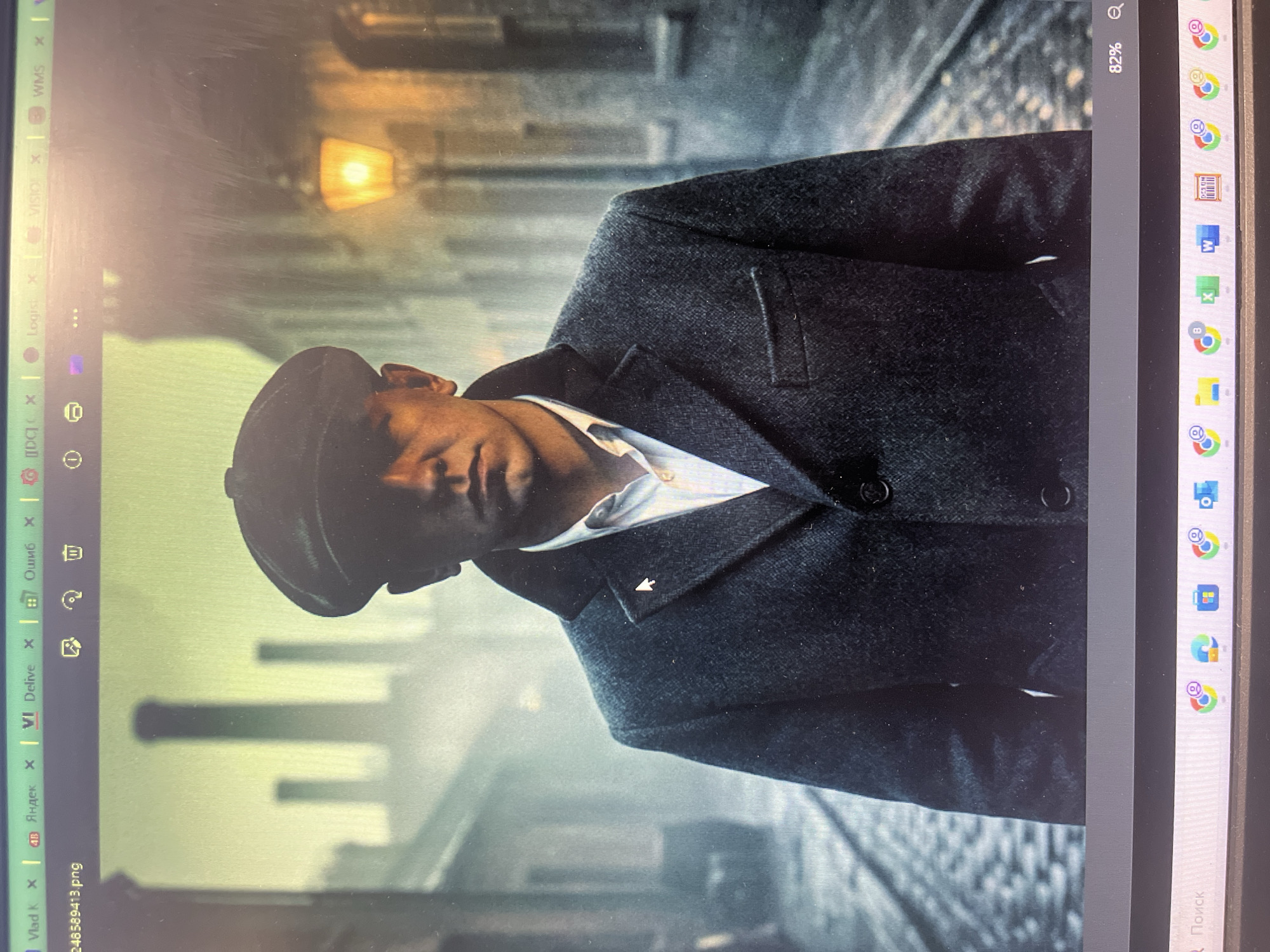 The image depicts a man wearing a flat cap and a tweed coat, standing in what appears to be a cobblestone street with buildings and smokestacks in the background. A gas lamp is visible on the right side of the image. The overall scene has a vintage or period aesthetic. The provided image does not contain any information or visual cues to suggest that the location is Lupanovo, Russia.