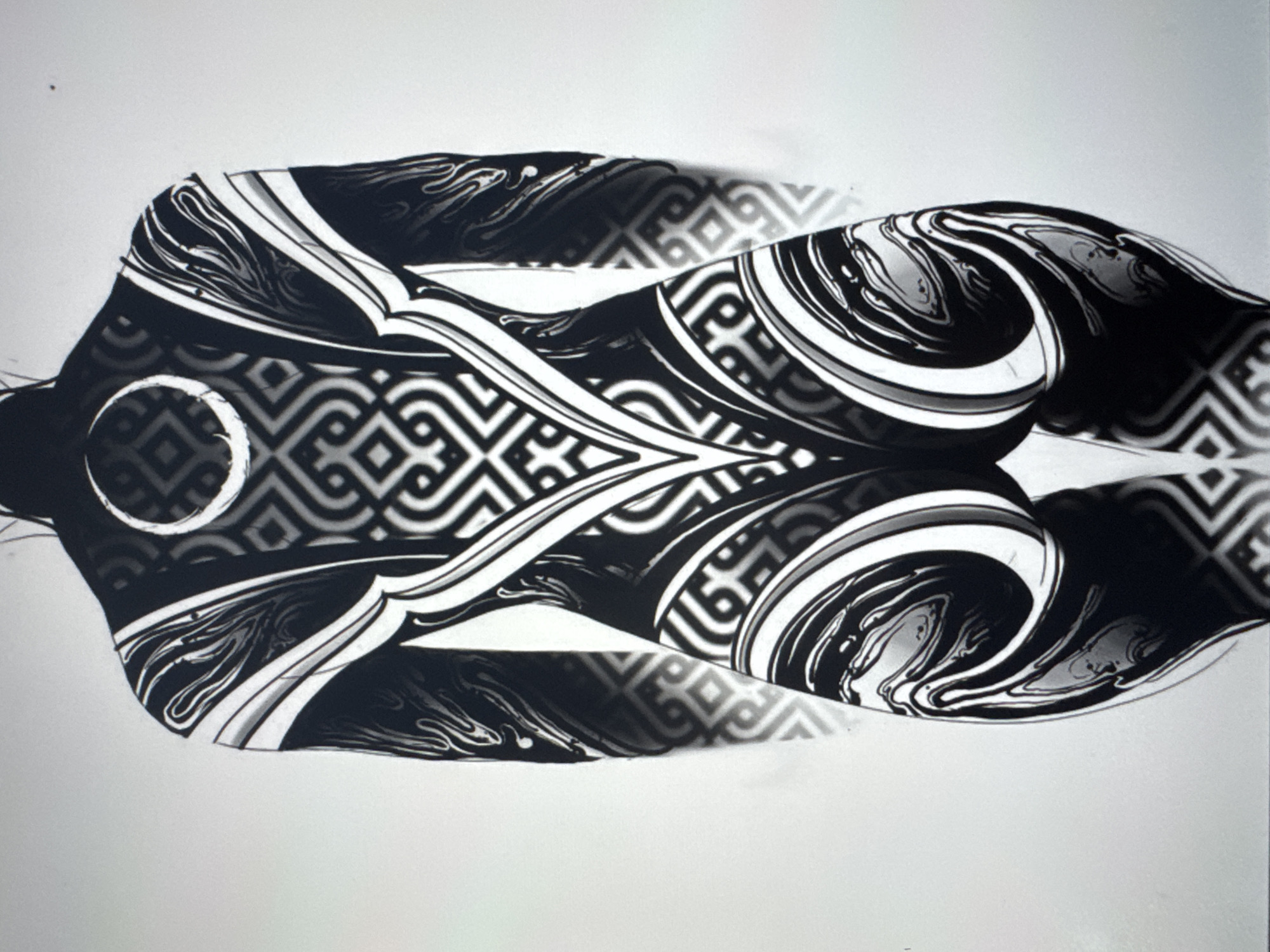 This black and white image features a stylized depiction of a human torso covered in intricate patterns. The body is positioned horizontally, facing upwards and slightly to the left. The artwork's style is abstract, with flowing lines and geometric shapes that create a sense of movement and depth.
The patterns on the torso consist of a combination of organic, swirling designs and sharp, angular motifs. A prominent circular element, possibly representing a navel or a decorative feature, is visible on the abdomen. The shading and linework suggest a three-dimensional form, with highlights and shadows contributing to the visual effect. The artwork appears to be a digital illustration or a heavily stylized photograph. The background is a plain, light color, likely white or a very pale gray, which contrasts sharply with the dark patterns on the subject. There is no discernible text within the image. The overall mood is artistic and somewhat surreal due to the abstract nature of the patterns and the rendering of the body.