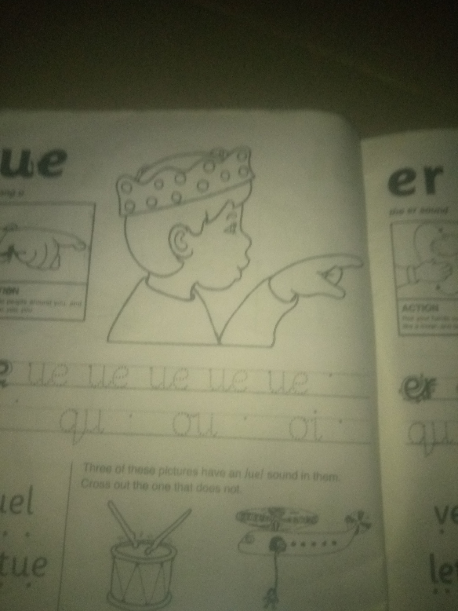 The image shows a page from a children's educational workbook. On the left side, the word "ue" is visible at the top, followed by a drawing of a hand pointing. Below that, there are lines with dotted letters "ue" repeated. Further down, dotted letters "qu" and "oi" are present. At the bottom left, the word "uel" is partially visible, with "tue" below it. In the center of the page, there is a drawing of a boy wearing a crown and pointing to the right. Below this drawing, a sentence reads, "Three of these pictures have an /ue/ sound in them. Cross out the one that does not." Beneath this sentence are drawings of a drum and an airplane. On the right side of the page, the letters "er" are prominent at the top, with the text "the er sound" below. Further down, a drawing is partially visible, followed by the letters "ex" and "qu." At the bottom right, the letters "ve" and "let" are visible. The workbook appears to be open on a surface, possibly a table, but the surrounding environment is not clearly visible. There is no information in the image that suggests a location in Jauro Yinu, Nigeria.