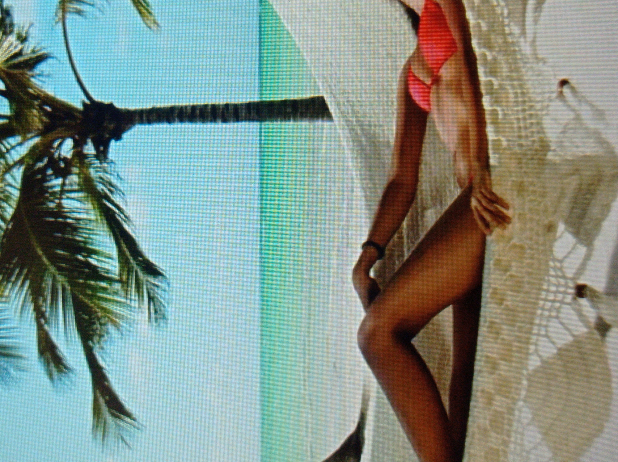 The image depicts a person lying in a hammock on a beach. The person is wearing a red bikini. A palm tree is visible in the background, with the ocean and sky beyond. The scene is peaceful and suggests a tropical or subtropical climate. The location is not specified as Mukachevo, Ukraine, but rather a beach setting.