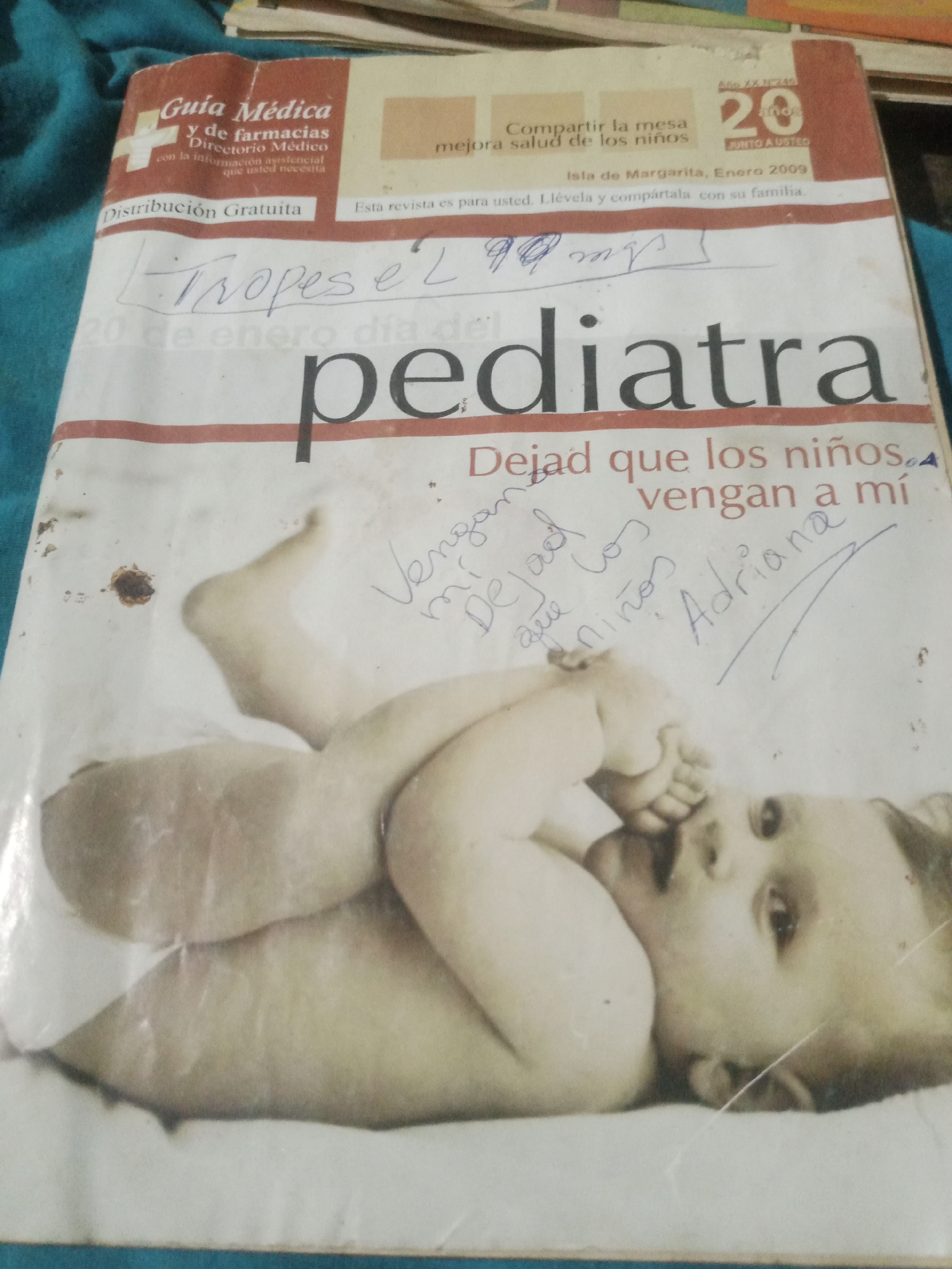 The image shows the cover of a magazine titled "Pediatra" with a photograph of a baby. The magazine is dated "Isla de Margarita, Enero 2009". There are handwritten notes on the magazine cover, including "Tropes é 2." and "Vengan mis, Dejad los niños. Adriana". The magazine appears to be a medical guide related to pediatrics and pharmacies, with "Guía Médica y de farmacias" and "Distribución Gratuita" visible. The location is identified as Santa Ana, Venezuela.