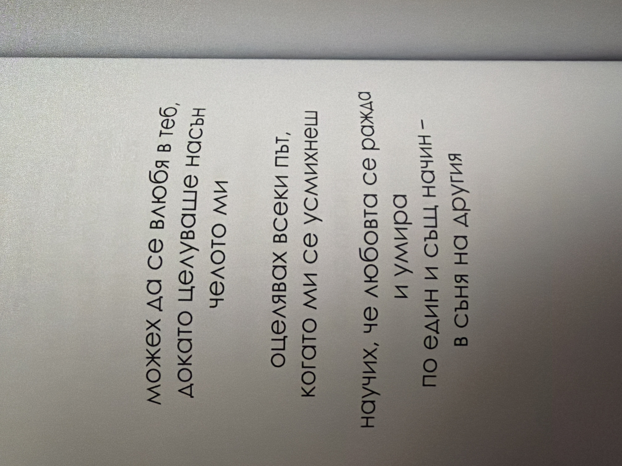 The image displays a section of text printed on a light-colored, slightly textured surface, resembling a page from a book or pamphlet. The text is in Cyrillic script and is centered on the page. The content appears to be poetic or philosophical. The lighting suggests the image was taken indoors, with a soft, diffused light source. There are no people, objects, or environmental features visible beyond the printed text and the surface it's on. The location within Pazardzhik, Bulgaria, cannot be determined from the visual information provided.