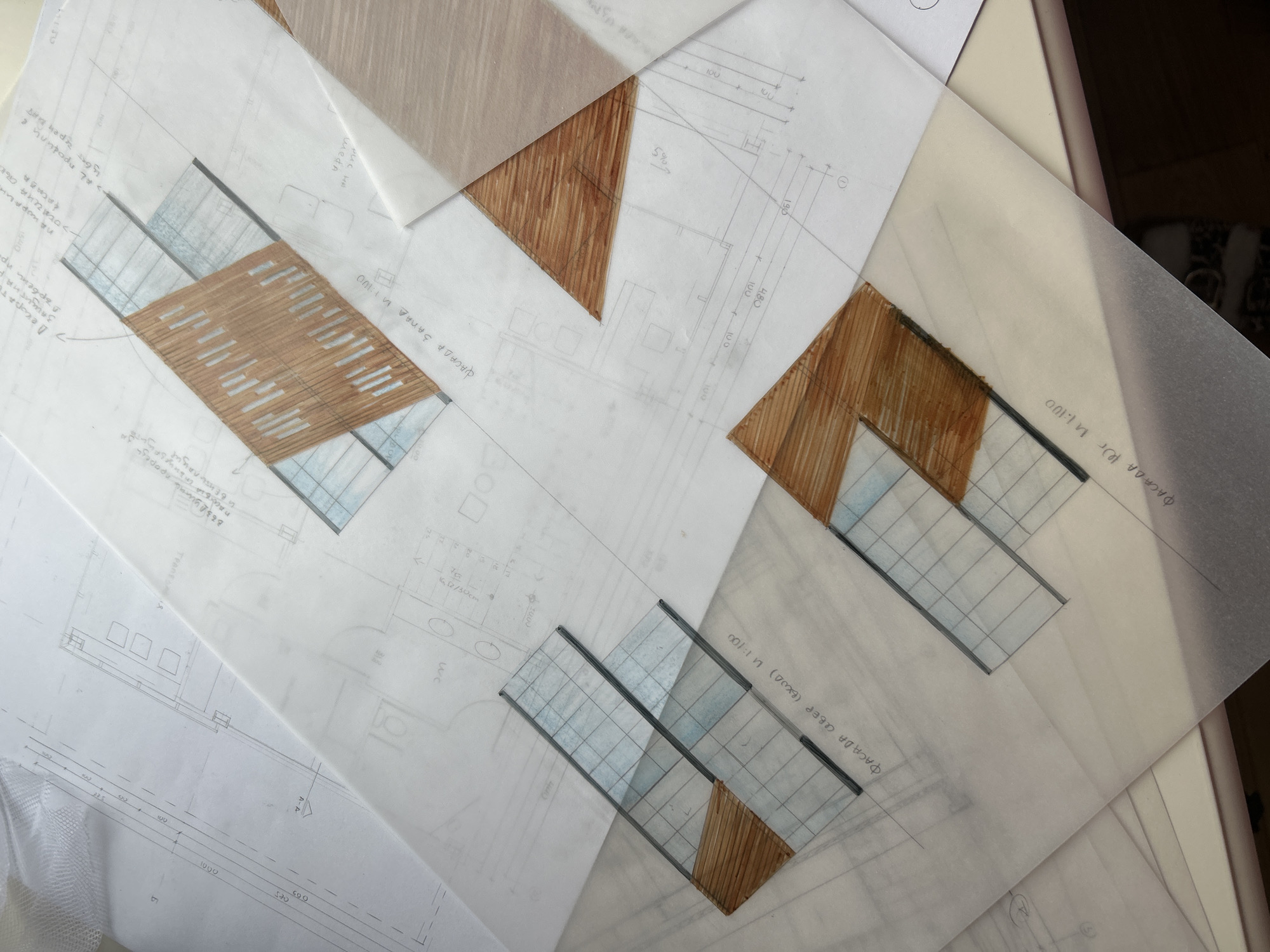 The image shows architectural sketches and designs overlaid on each other. These consist of floor plans, elevations, and details, likely related to a construction or renovation project. Some drawings are rendered with colored pencils, highlighting architectural elements such as wood panels and windows. The text in the sketches appears to be in Bulgarian. The OCR text includes "ФАСАДА," meaning "facade." Specific locations in Plovdiv, Bulgaria, cannot be determined from the image alone.