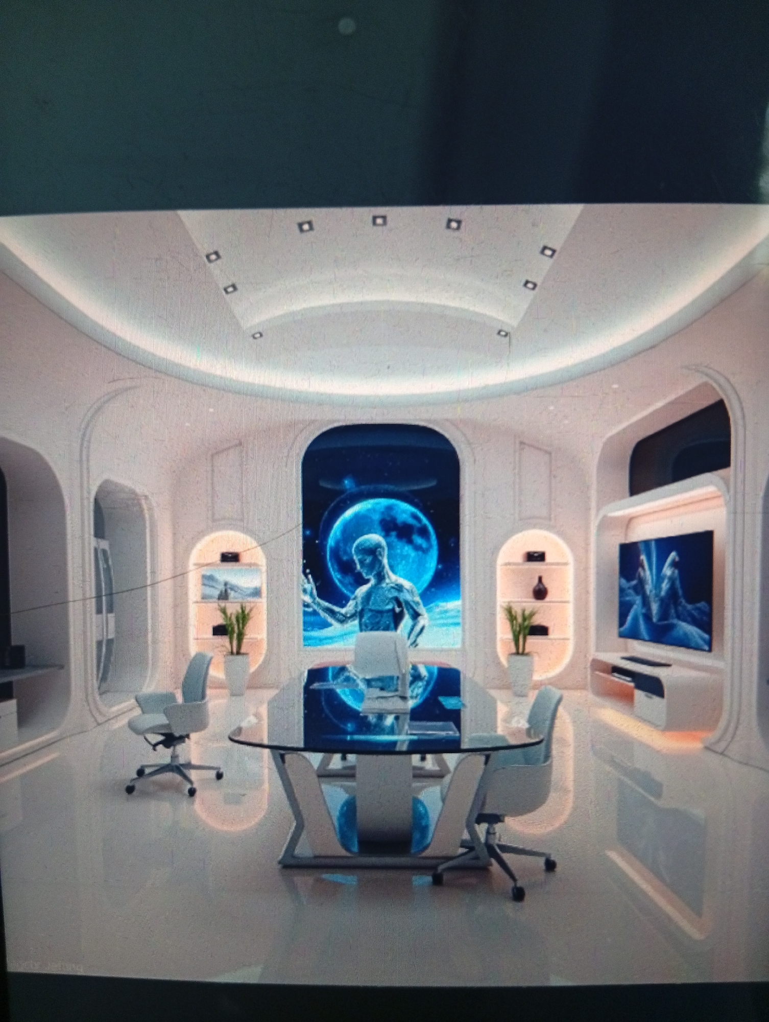 The image depicts a futuristic, minimalist office space with white walls and rounded architectural features. A glass-topped conference table with white supports sits in the center of the room, surrounded by four gray office chairs. A large screen displaying a blue-toned image of a human figure against a backdrop of a moon or planet is positioned at the far end of the room. On either side of the screen are arched alcoves, one containing a flat-screen TV and console, the other with shelves holding plants and decorative objects. The floor is shiny and reflective. There are no people visible, and the location is not Dutsen Alhaji, Nigeria.