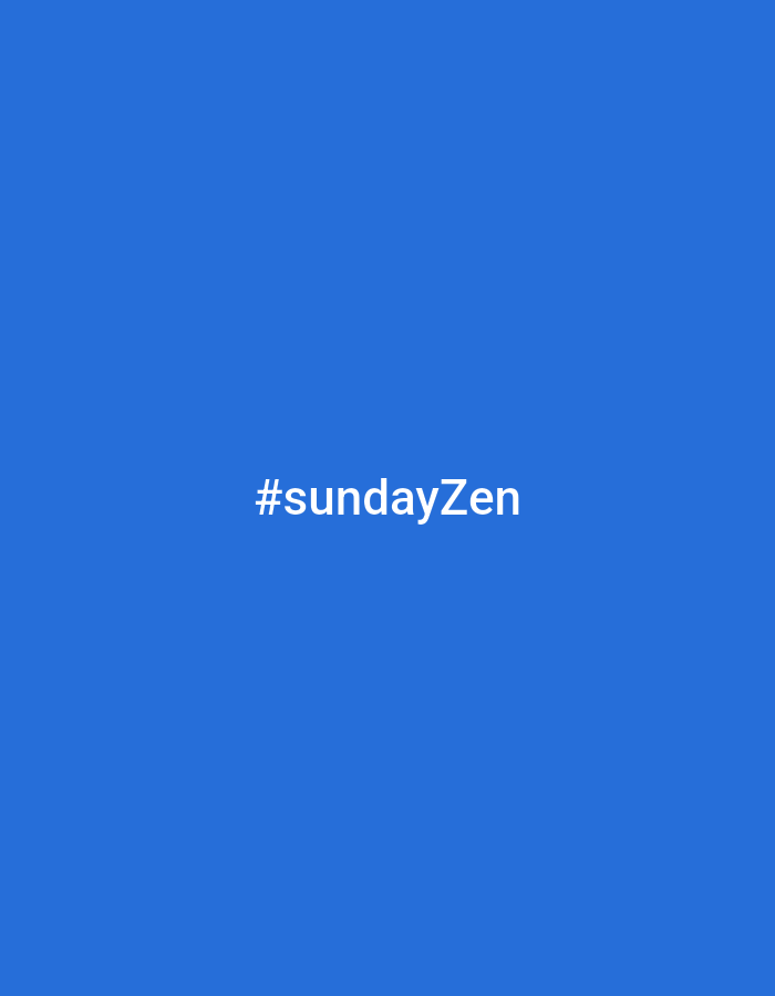 The image is a solid blue background with white text that reads "#sundayZen" centered horizontally and positioned slightly below the vertical center. There are no discernible people, subjects, objects, actions, interactions, or environmental details beyond the text and background color. The location in L'Île-Rousse, France, is not indicated by any visual cues in the image.