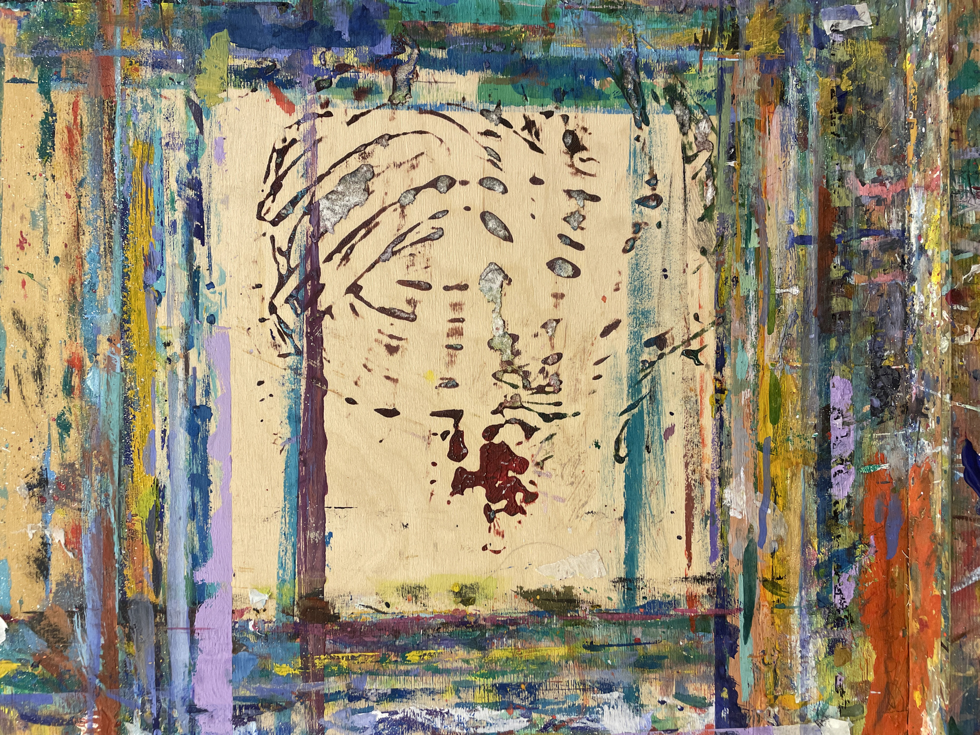 The image shows a paint-covered wooden surface, likely a palette or workbench. The central area is a lighter, bare wood, seemingly bordered by a rectangular frame of accumulated paint drips and splatters. These paint layers display a variety of colors including blues, greens, yellows, purples, reds, and browns. The central, unpainted area has faint traces of a drawing, possibly a stylized animal or abstract form, sketched in dark lines. A blotch of dark red paint is near the center of this bare wood area.
There is no information to suggest the location is in Khimki, Russia. The image is of an abstract painting, and any possible location information will be speculative.