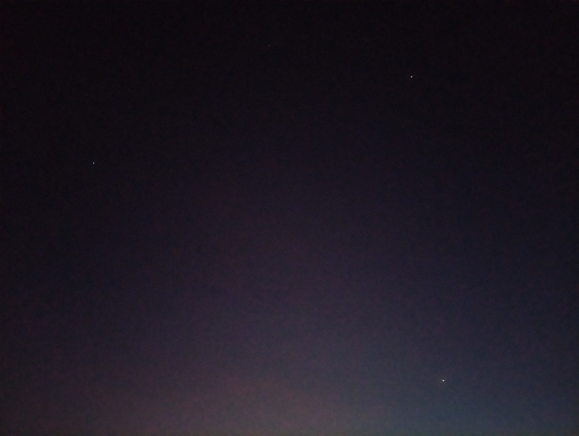A dark, almost black, night sky with a few visible stars. The bottom of the image shows a slight brightening, suggesting the horizon and possibly some light pollution. This photograph was taken in Ikorodu, Nigeria.
