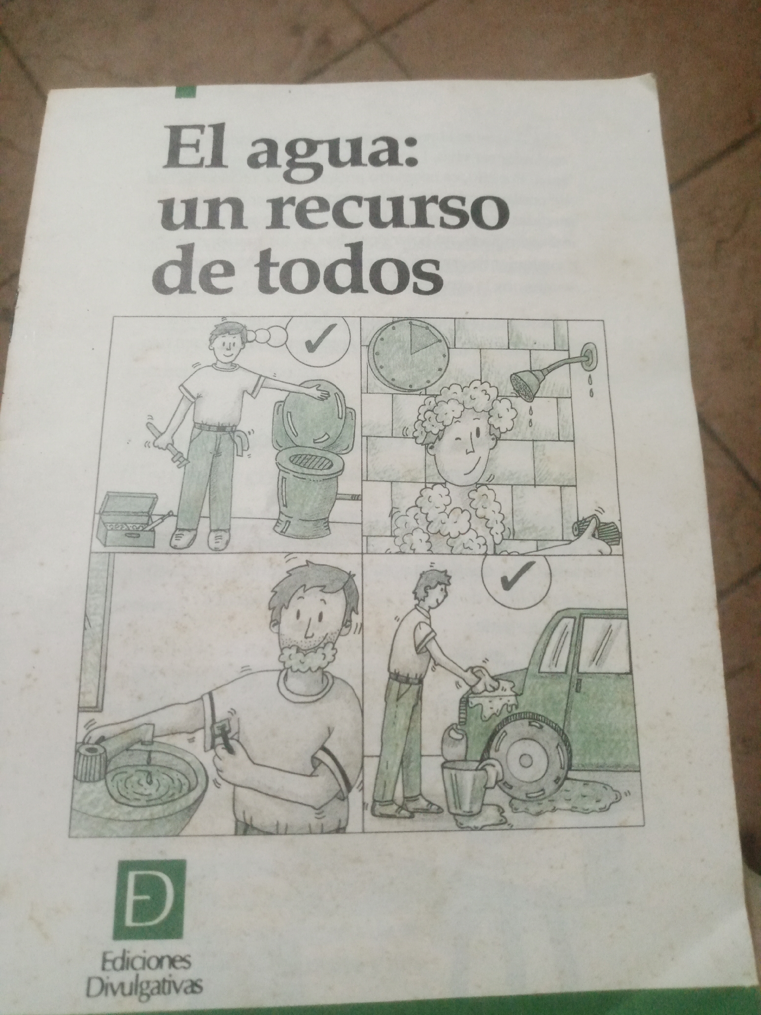 The image is a close-up of a book cover with the title "El agua: un recurso de todos" (Water: a resource for everyone) in bold black lettering. Below the title, there are four illustrations depicting scenes related to water usage and conservation.
The top left illustration shows a person holding a wrench and standing next to a toilet, with a toolbox open at their feet. A checkmark is depicted above their head.
The top right illustration shows a person showering, with water droplets falling from a showerhead. Bubbles are around their head, and a clock on the wall indicates time. A hand is shown holding a bar of soap.
The bottom left illustration shows a person shaving with a razor in front of a sink, with water in the basin. A checkmark is shown above their head.
The bottom right illustration shows a person washing a car with a sponge, with water and soap suds around the car. A bucket is also visible.
At the bottom of the book cover, there is a green square logo with a stylized "D" in white, followed by the text "Ediciones Divulgativas." The background of the image shows a textured surface, possibly a floor or table, with areas of light and shadow. The image quality is slightly blurry, and there are some visible specks of dirt or dust on the book cover. There is no information about the location in Santa Ana, Venezuela, within the provided image.
