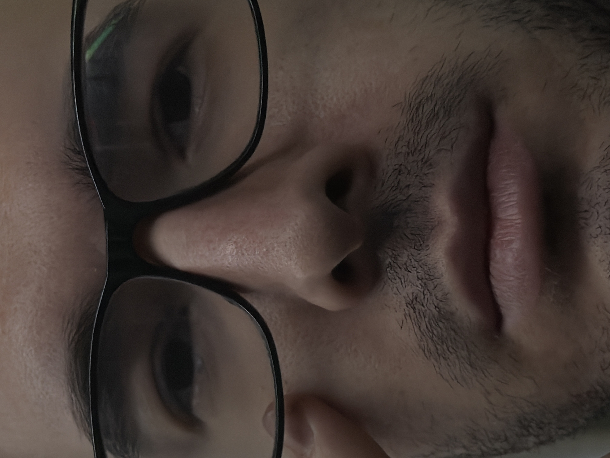 A close-up, rotated view of a person's face with glasses. The person has dark hair and a mustache. The location is unknown, Moscow, Russia is not deducible from the image.