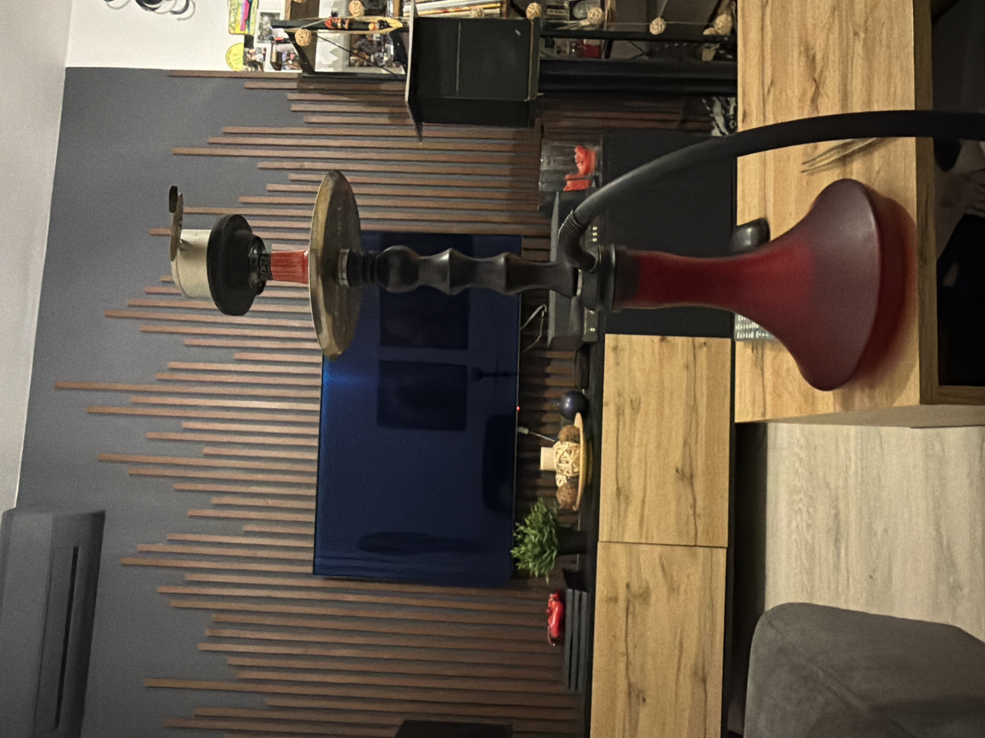 A hookah is positioned in front of a television and wall decor with horizontal wooden slats. The background shows a shelf with various items. The specific location within Sofia, Bulgaria cannot be determined from the provided image.