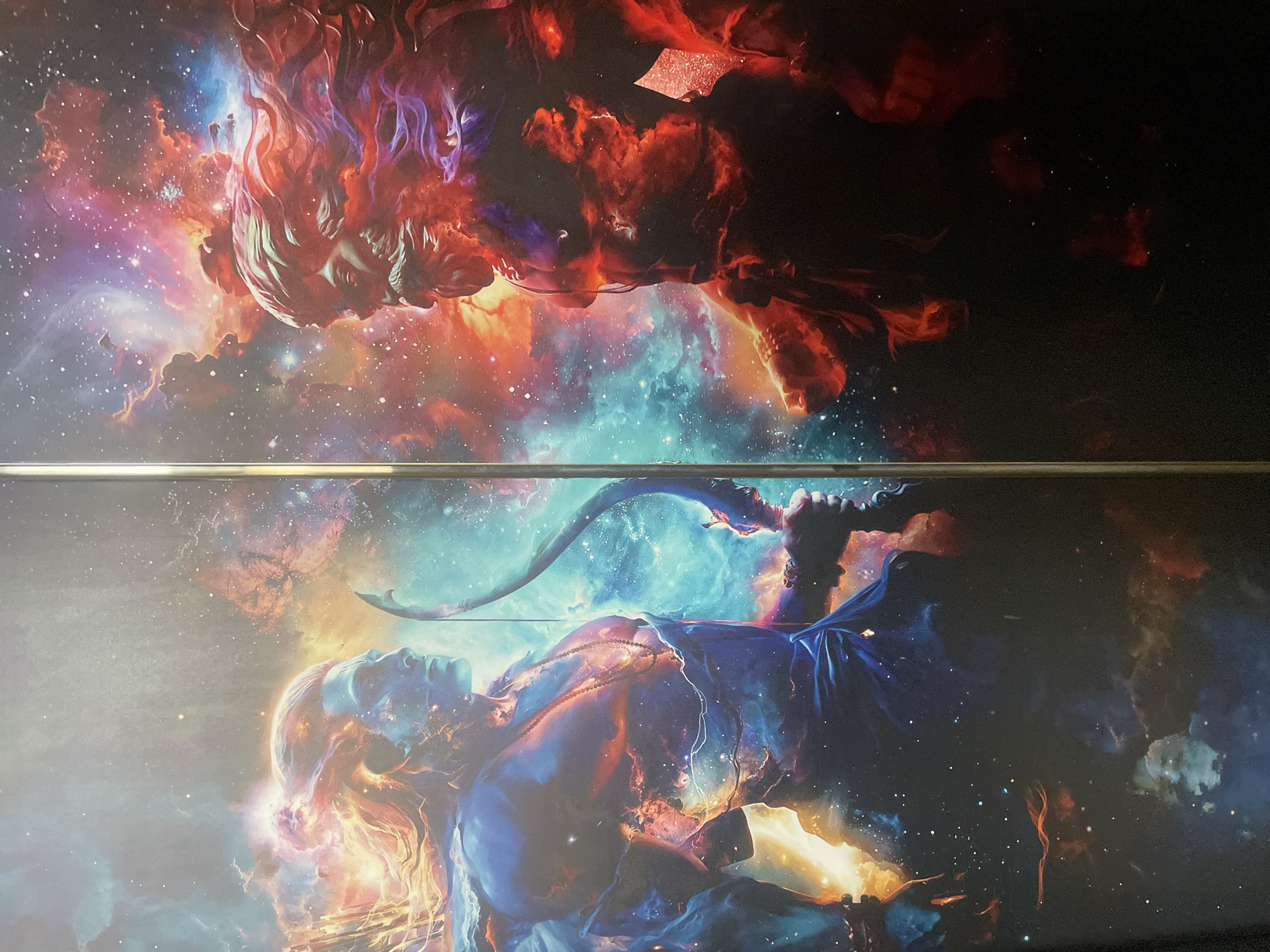 The image depicts two halves of a celestial-themed artwork, separated by a horizontal metallic bar. The upper half features a fiery, red-and-orange figure against a backdrop of deep space with nebulae and stars. The lower half shows a blue-toned figure with a drawn bow and arrow, also set against a starry, nebular background. The figures are stylized and appear to be composed of celestial elements. The location is Unknown, Unknown.