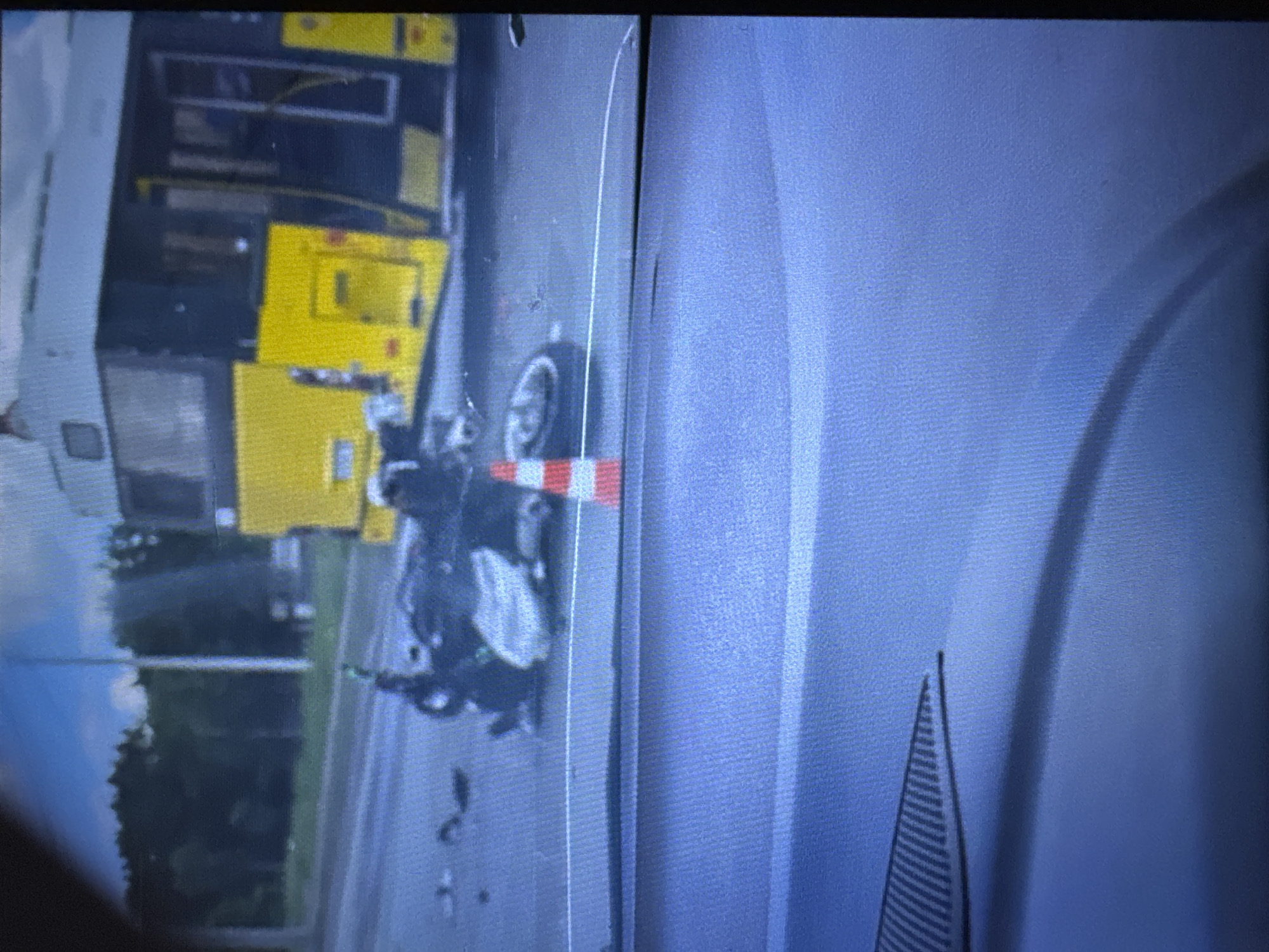The image appears to show the aftermath of a traffic accident involving a yellow bus and a motorcycle. The motorcycle is lying on its side next to a traffic cone. Debris is scattered around the motorcycle. A silver or gray vehicle is located on the right of the image.
Based on the assumption that it occurred in the city of Chaikovsky, Russia, without more context, I am unable to provide any more details, such as the exact location, the time of day, or information about people involved.