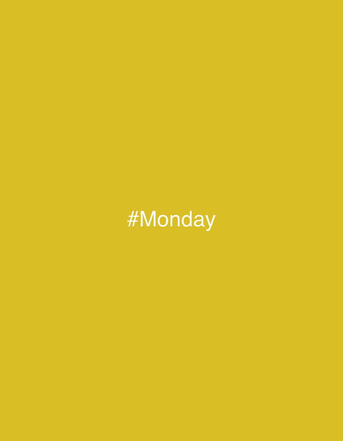 The image is a photograph with a plain, solid yellow background. Centered in the middle of the image is white text that reads "#Monday". There are no people, objects, or any environmental context present in the photograph other than the text against the colored background. The location in the city of Norviliškės, Lithuania is not depicted or implied in this image.