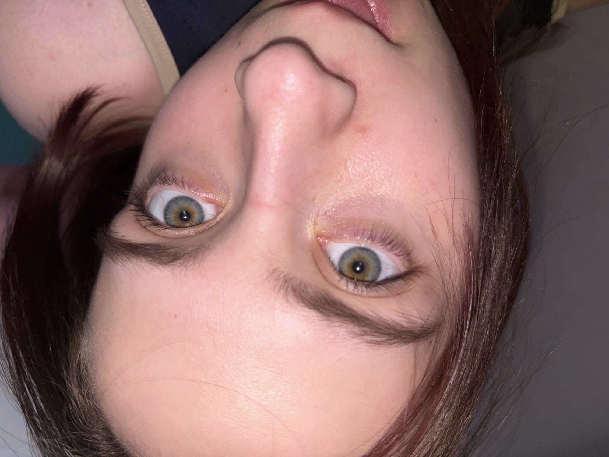 A close-up, upside-down shot depicts a person's face, focusing on the nose and eyes. The eyes are light green/hazel in color. The skin tone is fair, and the hair is dark. The photo is well-lit, showing fine details of the skin and hair. No specific landmarks or environmental details indicate a location in Прикамский, Russia. The focus is solely on the person's facial features.