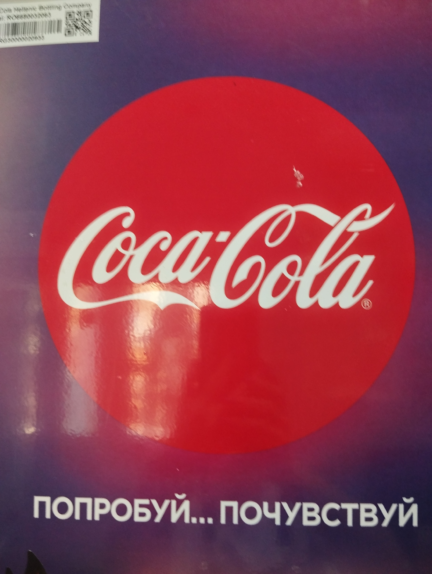 The image shows a Coca-Cola advertisement. The text below the Coca-Cola logo is in Russian: "ПОПРОБУЙ... ПОЧУВСТВУЙ" (TRY... FEEL). In the upper left corner is text related to the Coca-Cola Hellenic Bottling Company. No specific information or details identify the location as Krasnogorskoye, Russia.
