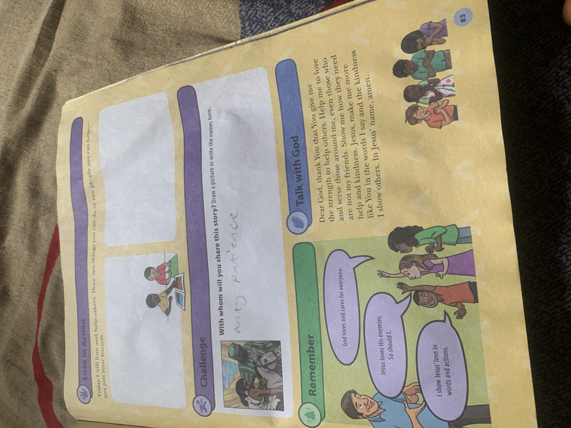 This is an image of a workbook page open to a religious lesson. The page has sections titled "Love in Action," "Challenge," "Remember," and "Talk with God." There are illustrations of children and adults, speech bubbles with text, and blank spaces for drawing. The lesson appears to focus on themes of love, kindness, and faith. The background of the image is a textured brown surface, possibly fabric. There is no indication of the image being from Jauro Yinu, Nigeria.