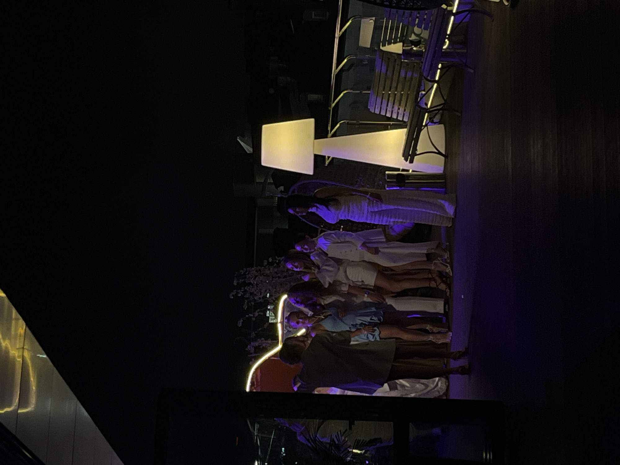 A group of about six people are standing in a row outside, with lighting. They appear to be posing for a picture. The location appears to be in Kazan, Russia.