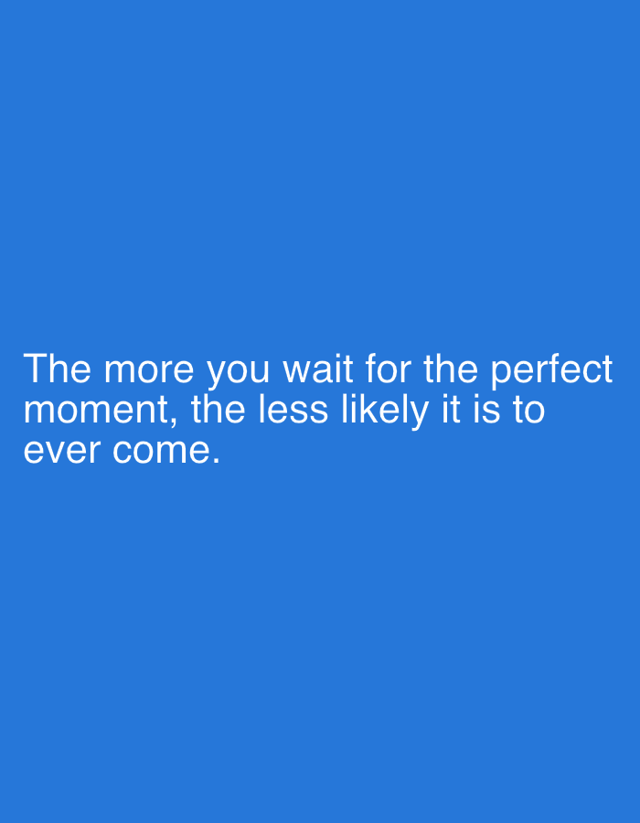 The image is a close-up, medium shot of white text on a vibrant blue background. The text is centered horizontally and occupies the lower half of the frame. The text reads: "The more you wait for the perfect moment, the less likely it is to ever come." There are no people, objects, or environmental details visible in the image, as it is solely composed of text on a solid color background. The location is unknown.