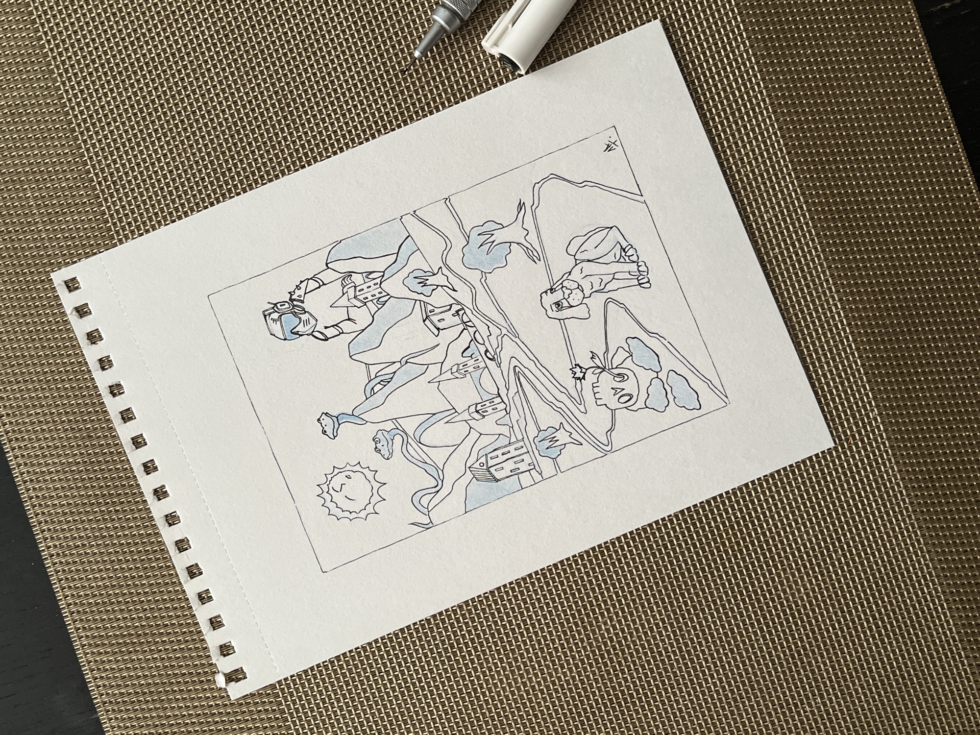 The image shows a spiral-bound notebook page with a drawing in black ink. The drawing depicts a fantastical scene with characters in a somewhat surreal or cartoonish style. The subjects seem to be engaged in dynamic movement or action. There is also a small drawing of a sun in the lower-left corner. The page is placed on a textured surface with a black pen and a white-capped marker near the top. There are no indications of Krasnoyarsk, Russia or its environment.