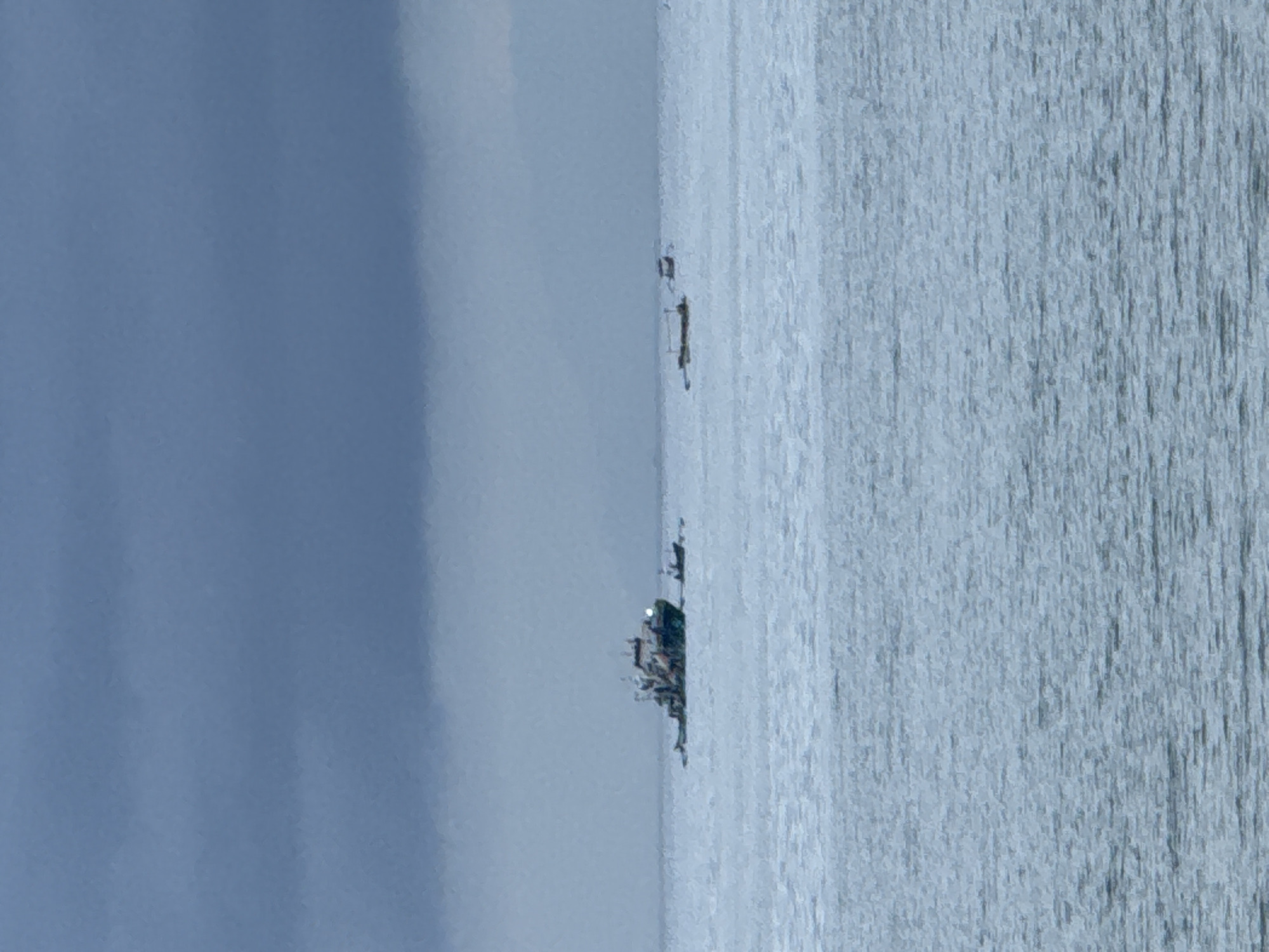The image shows a seascape with a body of water on the right side and a cloudy sky on the left. Several ships or boats are visible in the distance along the horizon. The location is unspecified, and Kuta Selatan, Indonesia is not discernible from the image.