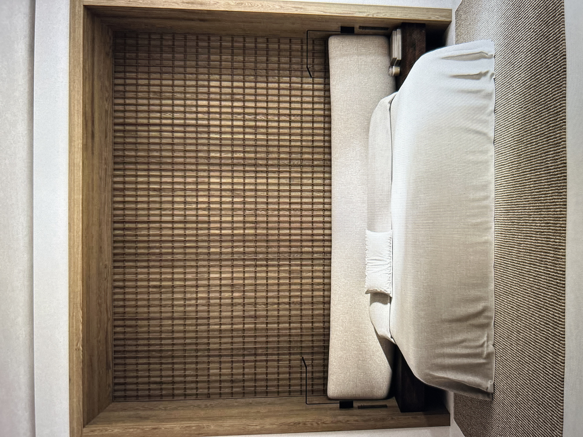 An interior shot of a bedroom features a large bed with a neutral-colored duvet and two pillows. The bed is positioned against a wall with a textured wooden paneling, framed by wooden beams. Two minimalist black wall lamps are mounted on either side of the headboard. On the right bedside table, there are a few books and a small cylindrical object, possibly a candle. A striped rug covers the floor in front of the bed, extending towards the viewer. The lighting is soft, creating a calm and sophisticated ambiance. The scene is devoid of any people. The location is an unknown city and an unknown place.