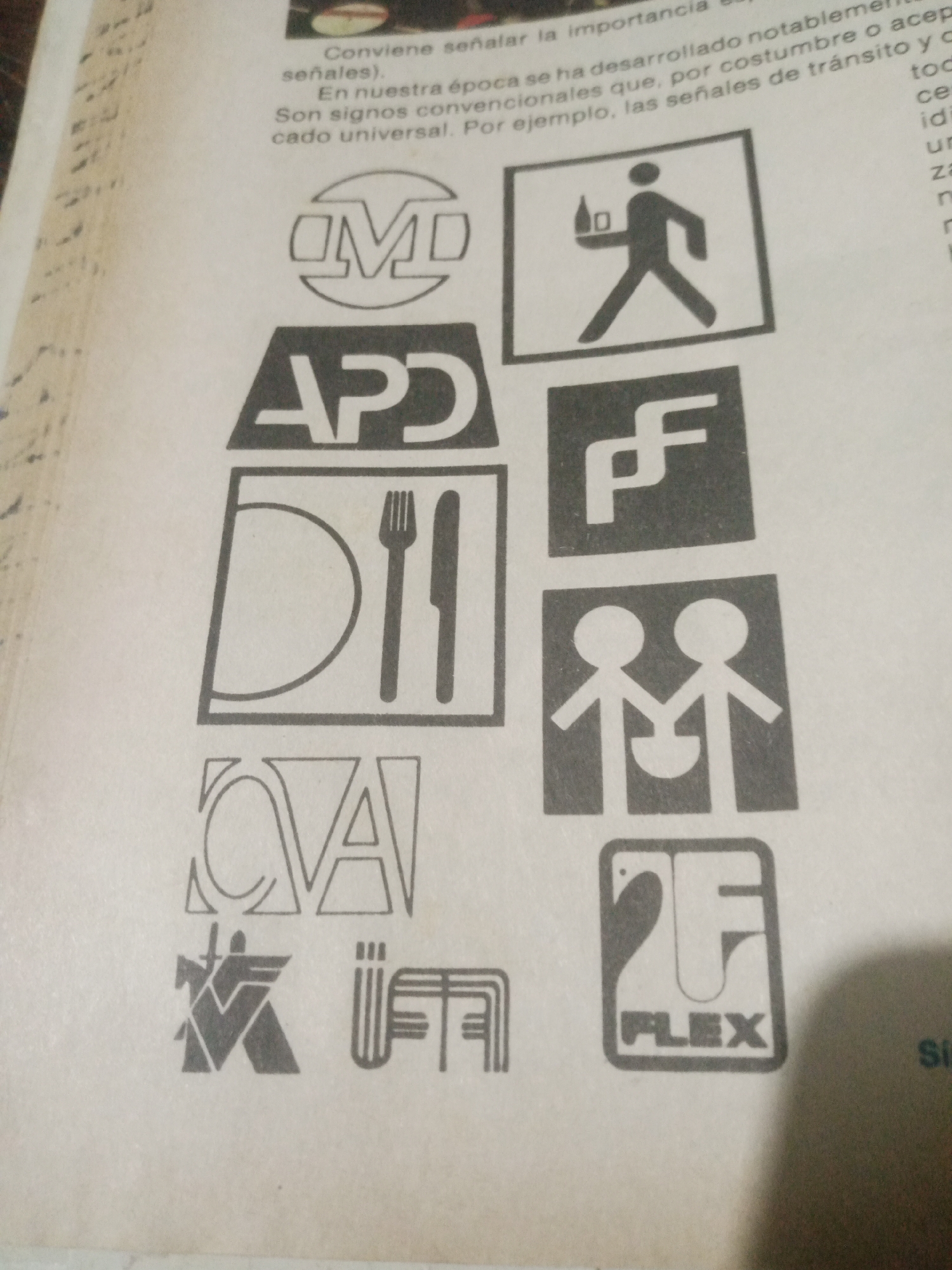 The image displays a collection of logos and text printed on what appears to be a page from a magazine or book. The logos are varied in design, with some featuring stylized letters, abstract shapes, and iconic representations. One logo depicts a person walking with a bottle, another shows two stick figures holding hands, and another contains a fork and knife. There is also text in Spanish that seems to be discussing the importance and development of conventional signs. The overall impression is a visual guide or catalog of symbols. The provided context of Santa Ana, Venezuela, is not visually supported by the image content itself, as there are no discernible landmarks or contextual clues to place the image within that specific city.