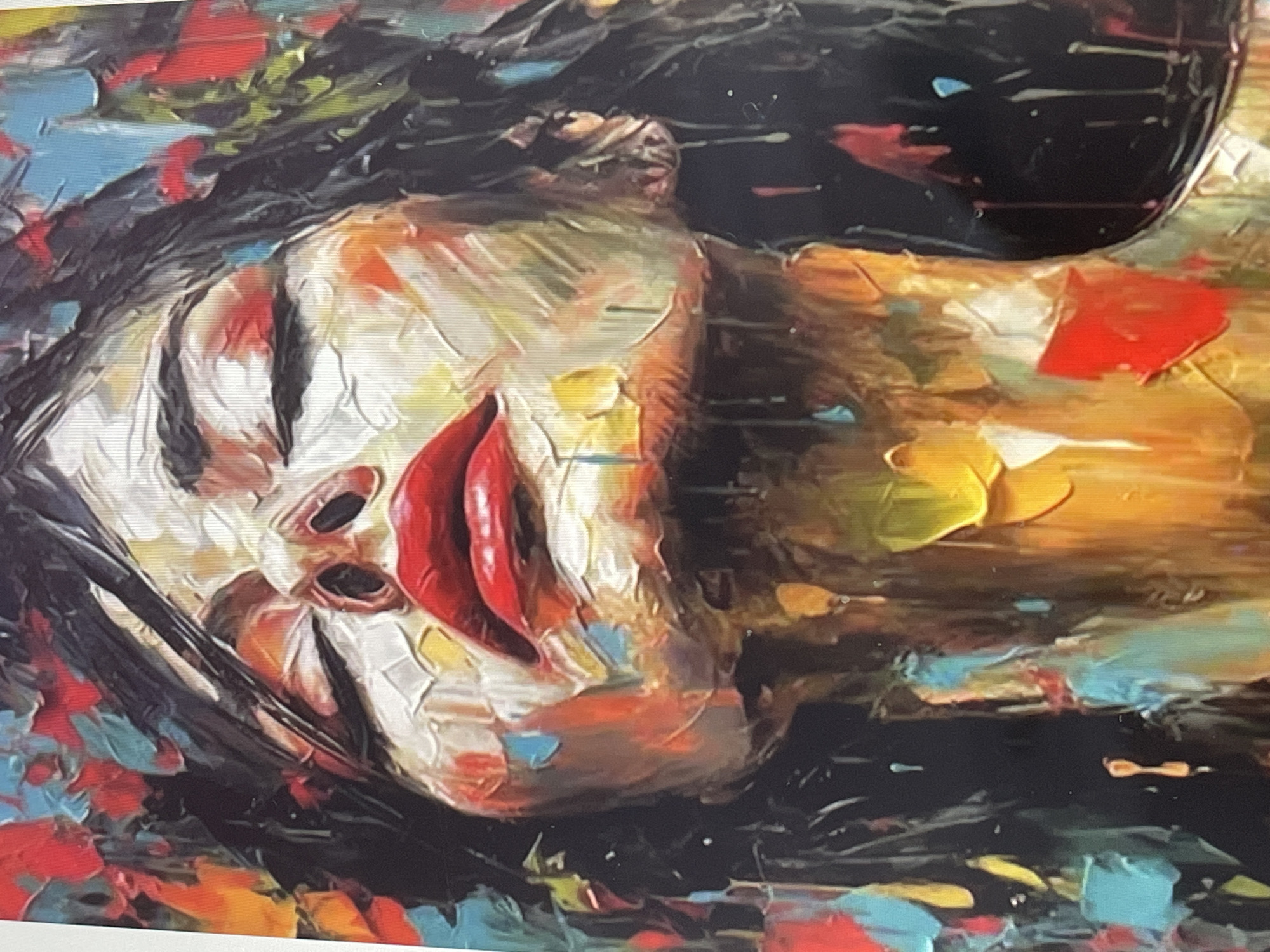 This is a close-up, abstract oil painting of a person's face. The face is rendered with thick, impasto brushstrokes, creating a textured and somewhat impressionistic effect. The prominent features include eyes, a nose, and full lips painted in a vibrant red. The person's face is tilted, and their eyes appear closed or partially closed, suggesting a state of rest, contemplation, or perhaps even sadness. The skin tones are a mix of white, flesh tones, and hints of other colors blended into the paint.
The background is a chaotic but colorful array of abstract shapes and colors, including black, red, blue, yellow, and green. These colors seem to represent hair or a garment, as well as abstract elements that surround the face, contributing to the overall dynamic and emotional feel of the artwork. The painting style suggests a focus on capturing feeling and essence rather than precise detail. There is no discernible text within the image. The time of day, weather, and specific location are not indicated.