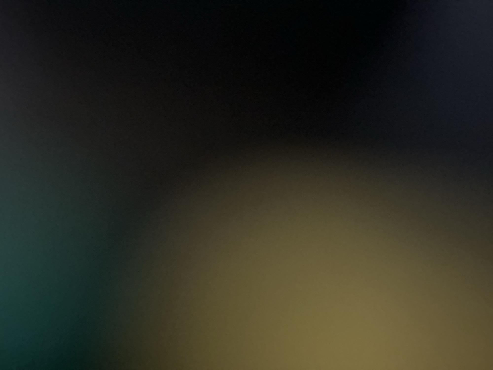 This image is an abstract, out-of-focus photograph with a gradient of colors transitioning from a dark teal in the upper left to black in the lower right, with a patch of golden-brown in the lower left quadrant. There are no discernible subjects, objects, or actions. The image does not provide any information that would allow for the identification of a specific location in Belgrade, Serbia, or any other city.
