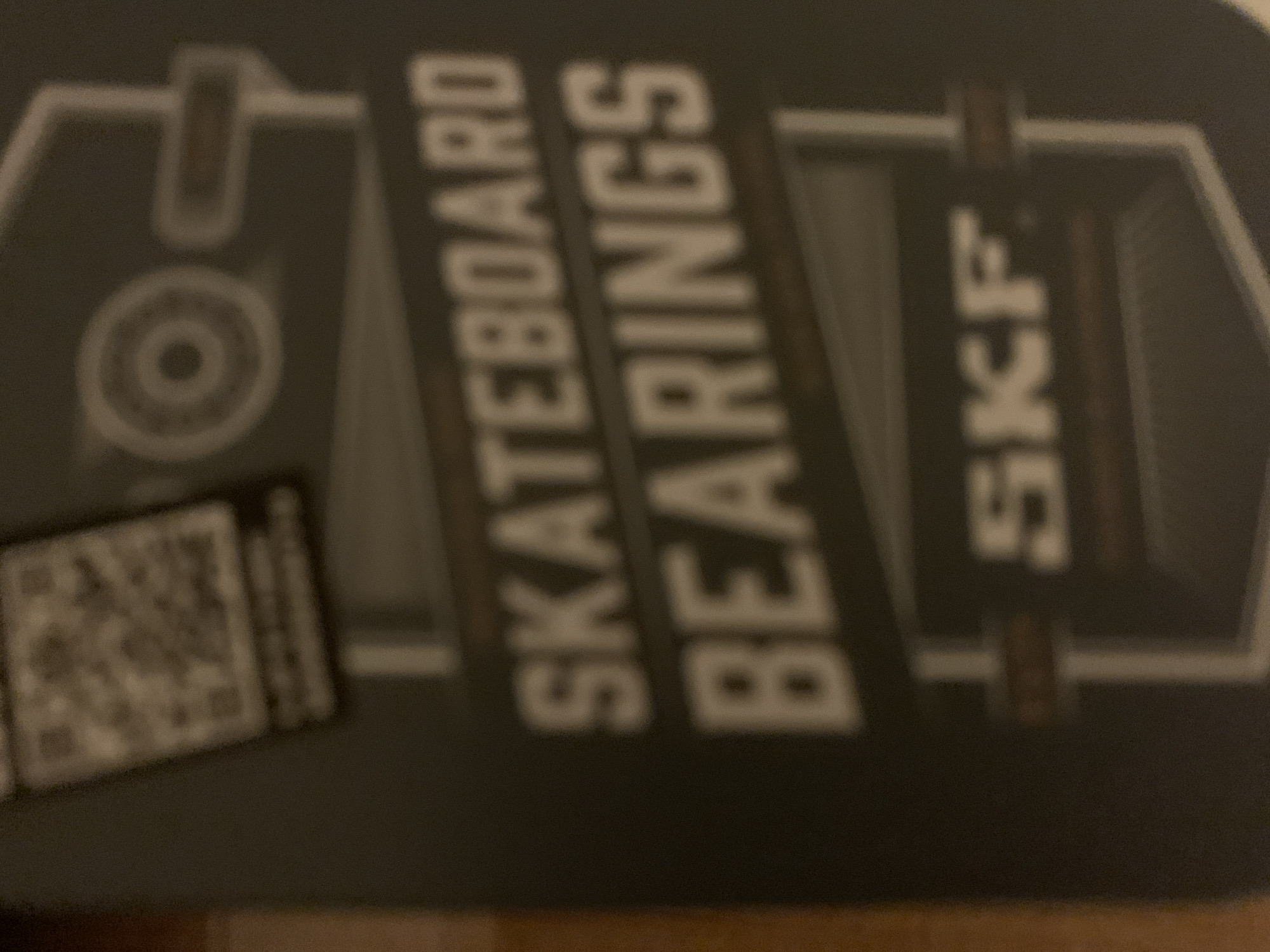 The image shows a package of SKF skateboard bearings. The text "SKATEBOARD BEARINGS" is printed prominently on the package. A QR code is also visible on the lower left. The location is not discernible from the image.