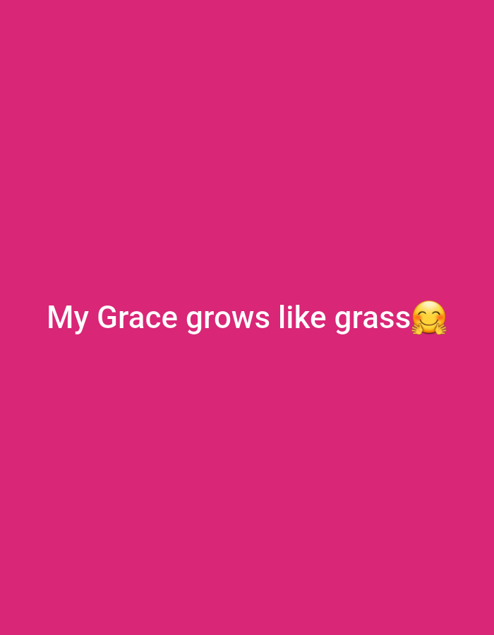 The image contains white text on a pink background. The text reads "My Grace grows like grass" followed by a smiling emoji with rosy cheeks. The background is a solid, vibrant pink color. There are no people, objects, or environmental features visible other than the text and emoji. There is no information in the image to suggest a location in Gwagwada, Nigeria.