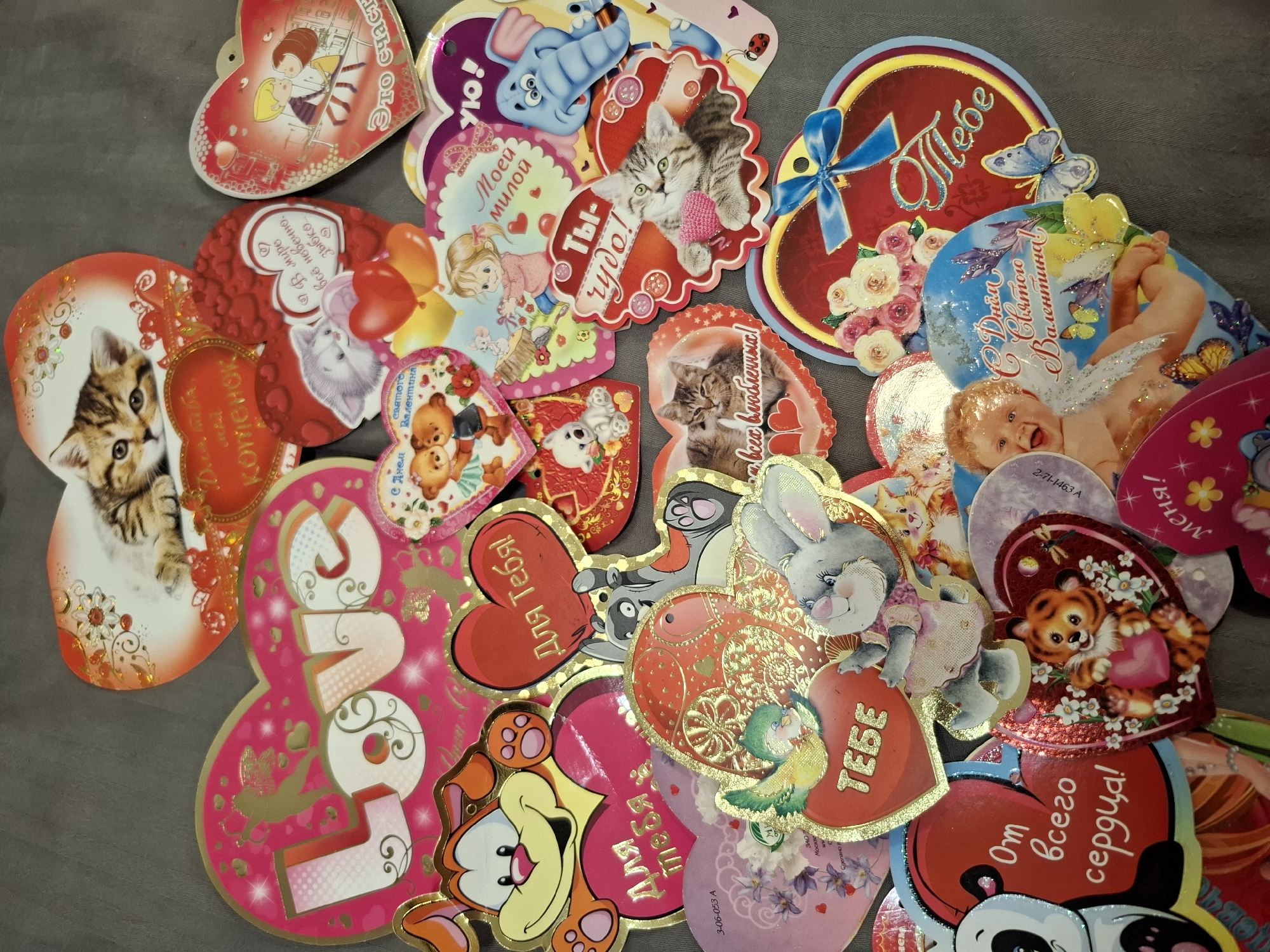 This image depicts a collection of Valentine's Day cards with various themes and designs, including images of cats, bears, a bunny, a cupid, and other cartoon characters. Many of the cards feature text in Russian, such as "Для тебя" (For you), "С Днем святого Валентина!" (Happy Valentine's Day!), and "Ты чудо!" (You are a miracle!). Some cards also have English text such as "LOVE". There is a reference to the city of Амзя, Russia.