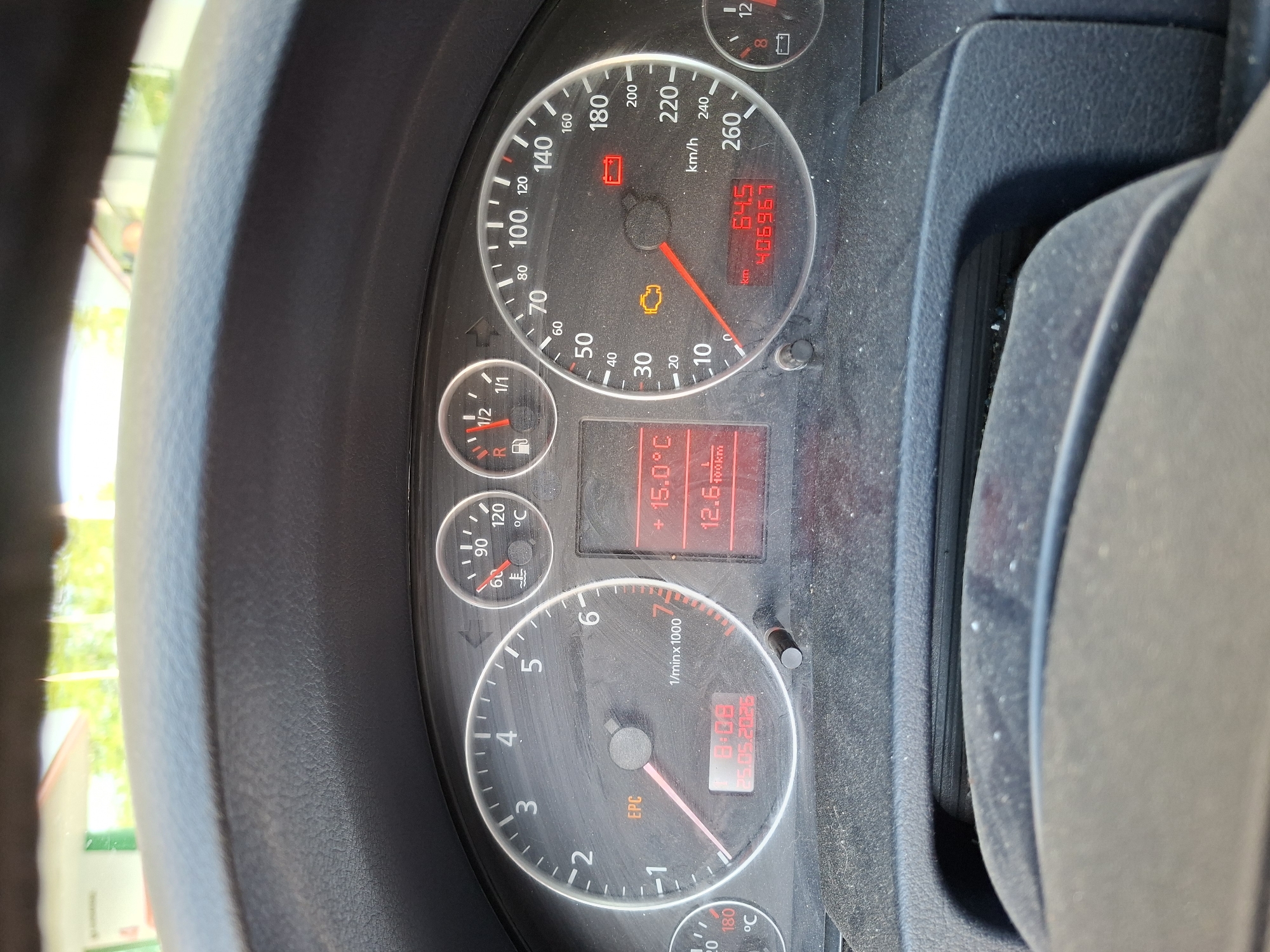 The image shows the dashboard of a car. The car's speedometer reads approximately 64.5 km/h, and the odometer shows 406967 km. The tachometer indicates the engine is running at around 1750 RPM. The fuel gauge is close to empty ("R" for Reserve). The coolant temperature is around 60°C, and the outside temperature is 15.0°C. The dashboard clock displays 8:09 on 25.05.2025. Warning lights for the battery and engine are illuminated. "EPC" is visible on the tachometer. The steering wheel is visible on both the left and right sides of the image. The location of the photo, Plovdiv, Bulgaria, is not discernible from the visual elements of the image.