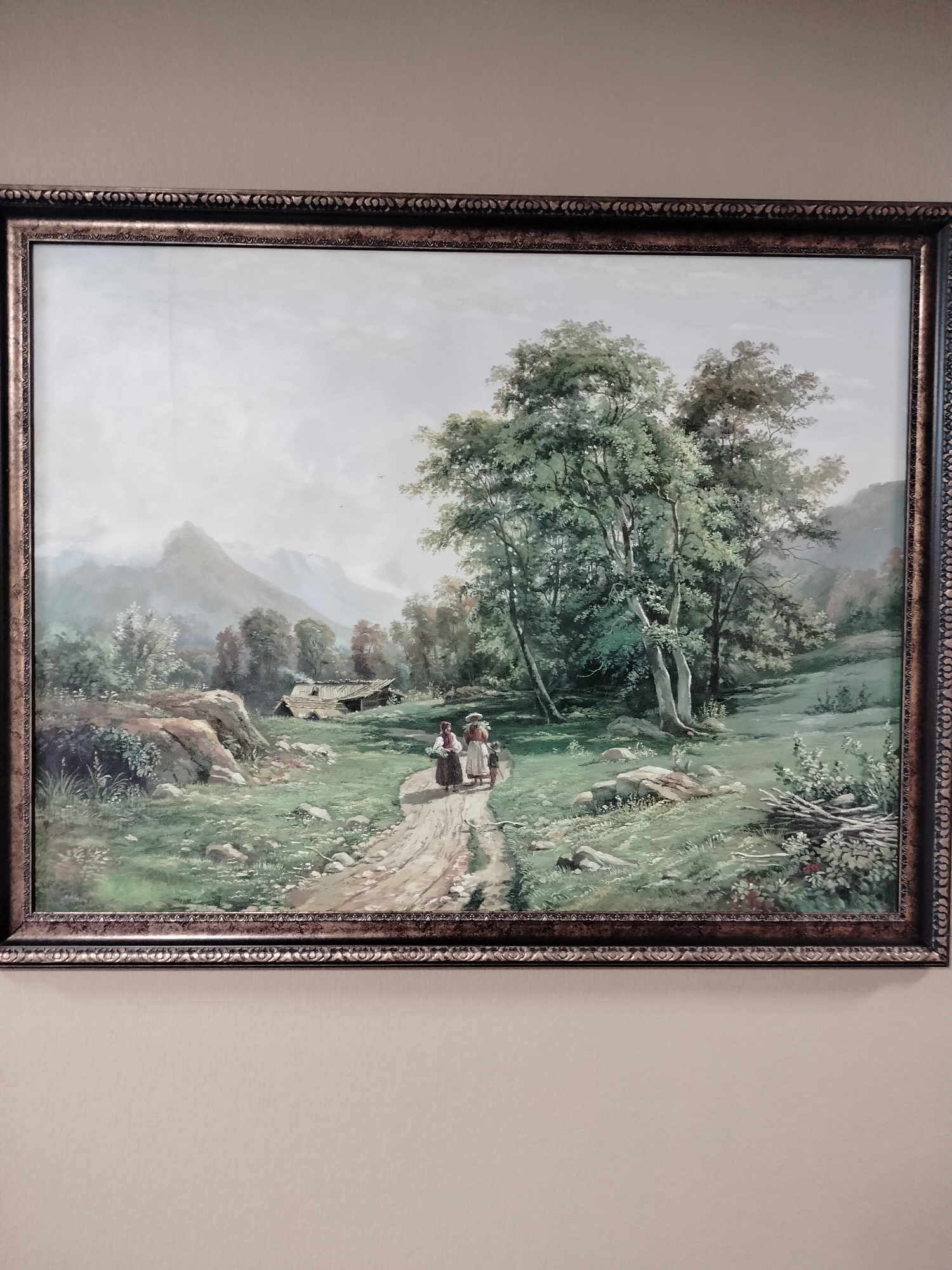 This is a framed painting depicting a pastoral landscape scene with a dirt path winding through a grassy meadow. Two women in traditional attire are walking on the path, carrying baskets. In the background, there is a rustic wooden cabin with a smoking chimney, nestled among trees. Further in the distance, misty mountains rise against a pale sky. The painting's style suggests it is an older work, possibly depicting a rural European setting, and does not appear to be specifically related to the city of Berezovo (село) (Novokuznetsky), Russia.