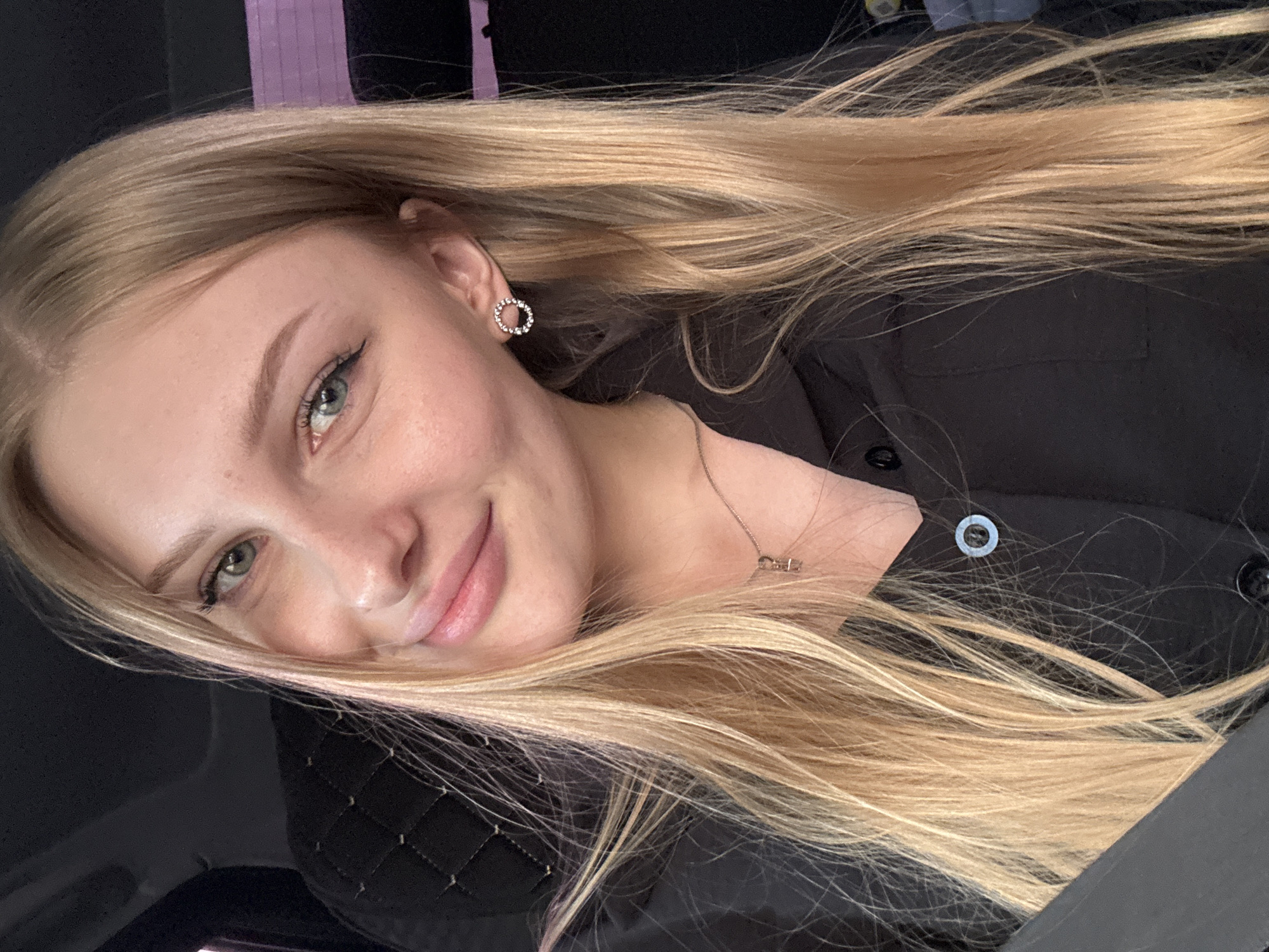 A woman with long blonde hair smiles at the camera. She is wearing a black top and a circular earring. The location is Кондратово, Russia.