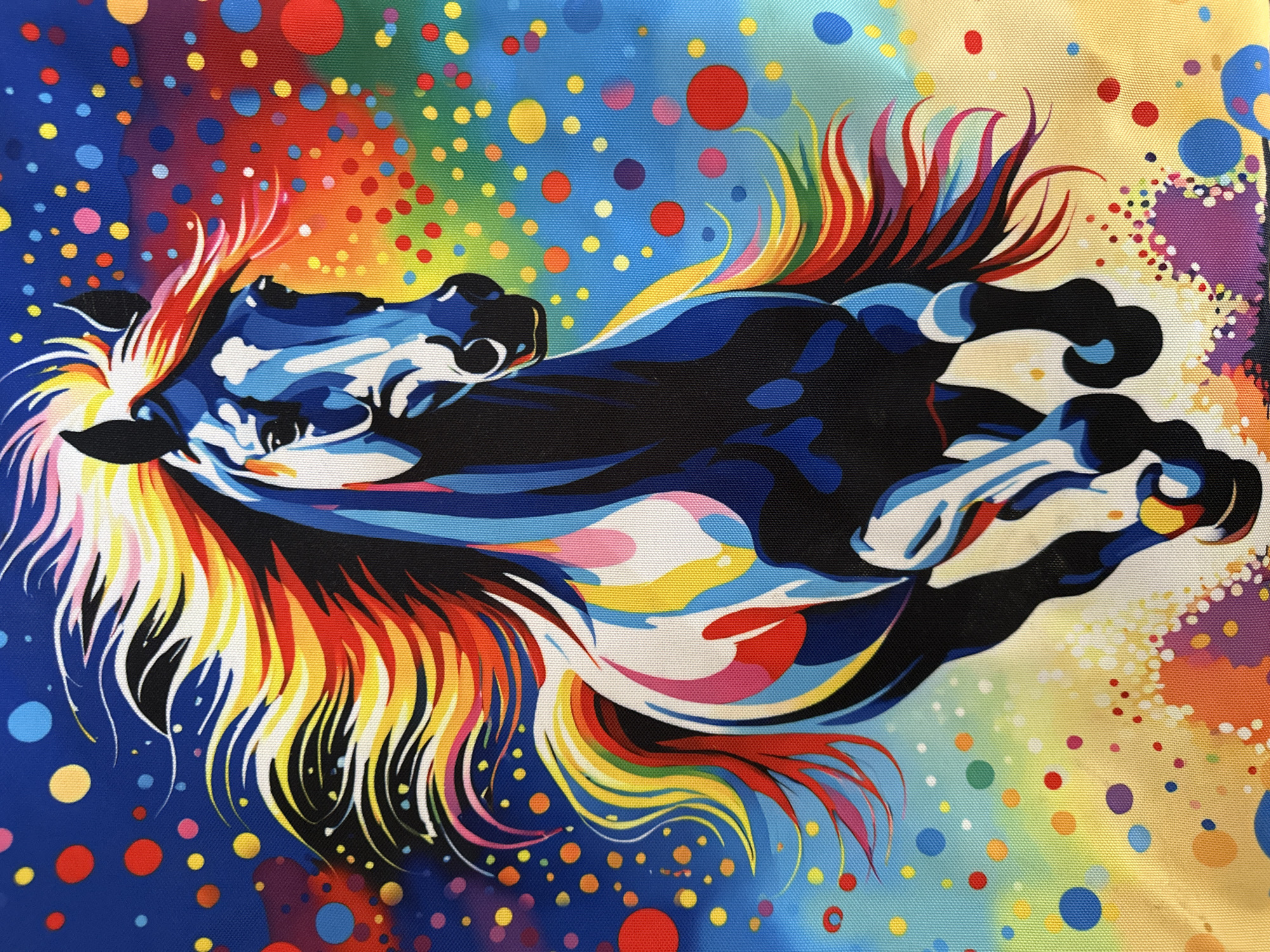 A vibrant, abstract image depicts a horse with flowing, multi-colored mane and tail. The horse is rendered in bold, graphic style with strong outlines and contrasting colors. The background features a colorful array of dots in varying sizes, creating a lively, dynamic feel. The overall impression is artistic and whimsical. There is no evidence of the location being in Chaikovsky, Russia.