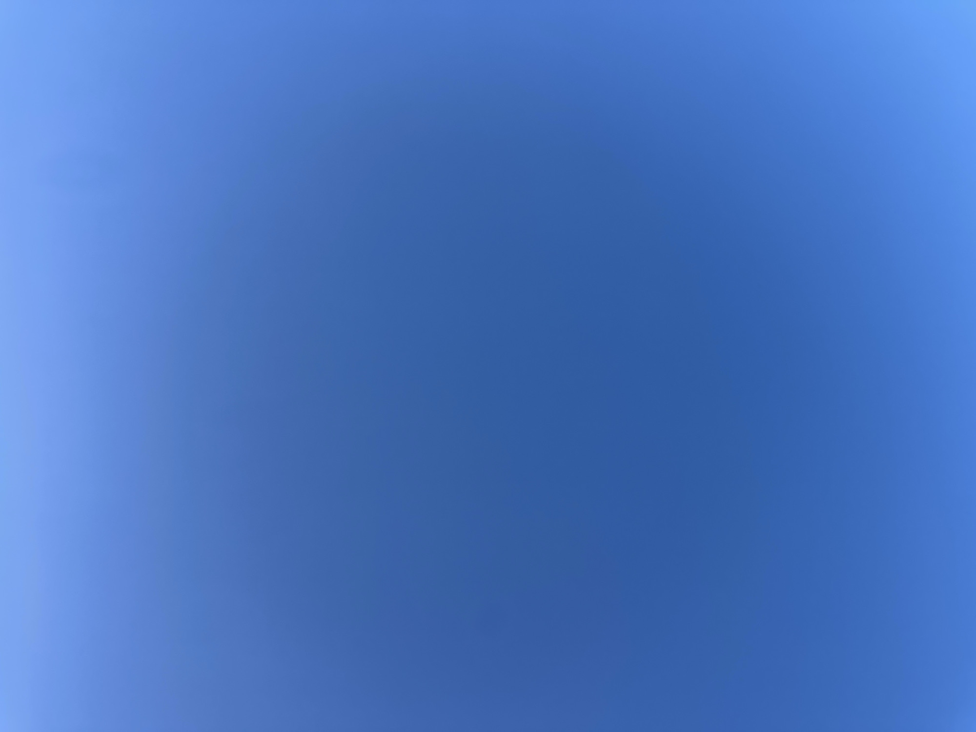 The image depicts a clear blue sky. There are no visible objects, people, or subjects present. The environment consists solely of the uniform blue expanse of the sky. The location in Wealden, United Kingdom cannot be determined from the image alone.