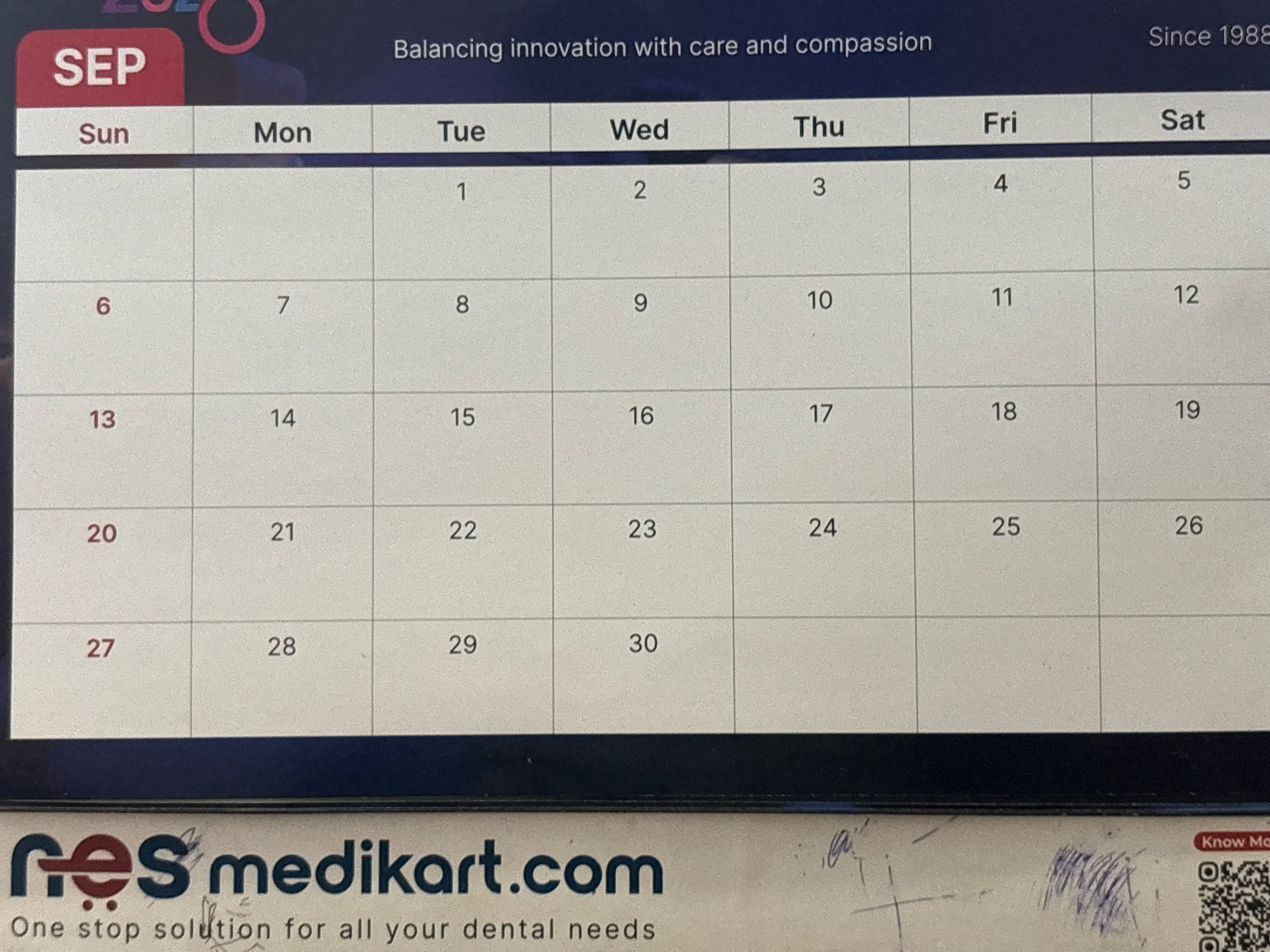The image shows a calendar page for September, with days of the week listed across the top: Sun, Mon, Tue, Wed, Thu, Fri, Sat. The days of the month are numbered within the grid, starting with September 1st on a Tuesday. The calendar is part of a larger backdrop that includes the text "SEP" in a red rectangle at the top left, and "Balancing innovation with care and compassion" and "Since 1988" at the top right. Below the calendar is a logo and text that reads "res medikart.com" and "One stop solution for all your dental needs". The lower right corner of the image also shows a QR code and the text "Know Mo". The calendar appears to be a digital display or printout. There are no people or specific locations mentioned in the scene.