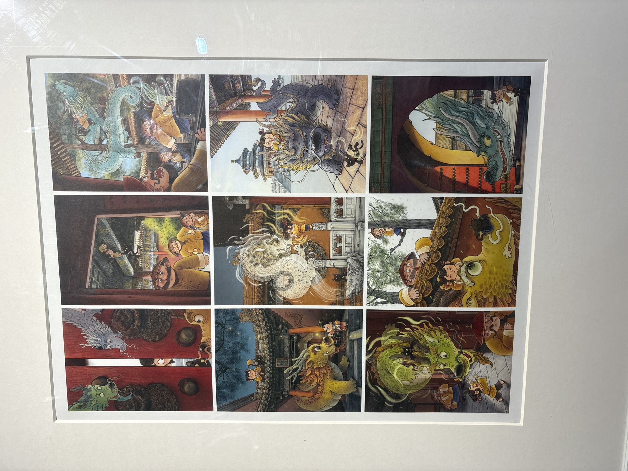 The image is a framed collage of nine cartoon-style illustrations. Each illustration depicts a different scene involving dragons and humans, with architectural elements suggesting a Chinese setting. The dragons vary in color and design, including blue, gray, green, white, and yellow. The humans, dressed in traditional Chinese clothing, interact with the dragons in various ways, such as riding them or looking at them in surprise. The background architecture features pagodas, doorways, and building details typical of Chinese design. The location in Nan'an District, China, is inferred from the architectural style prevalent in the illustrations.