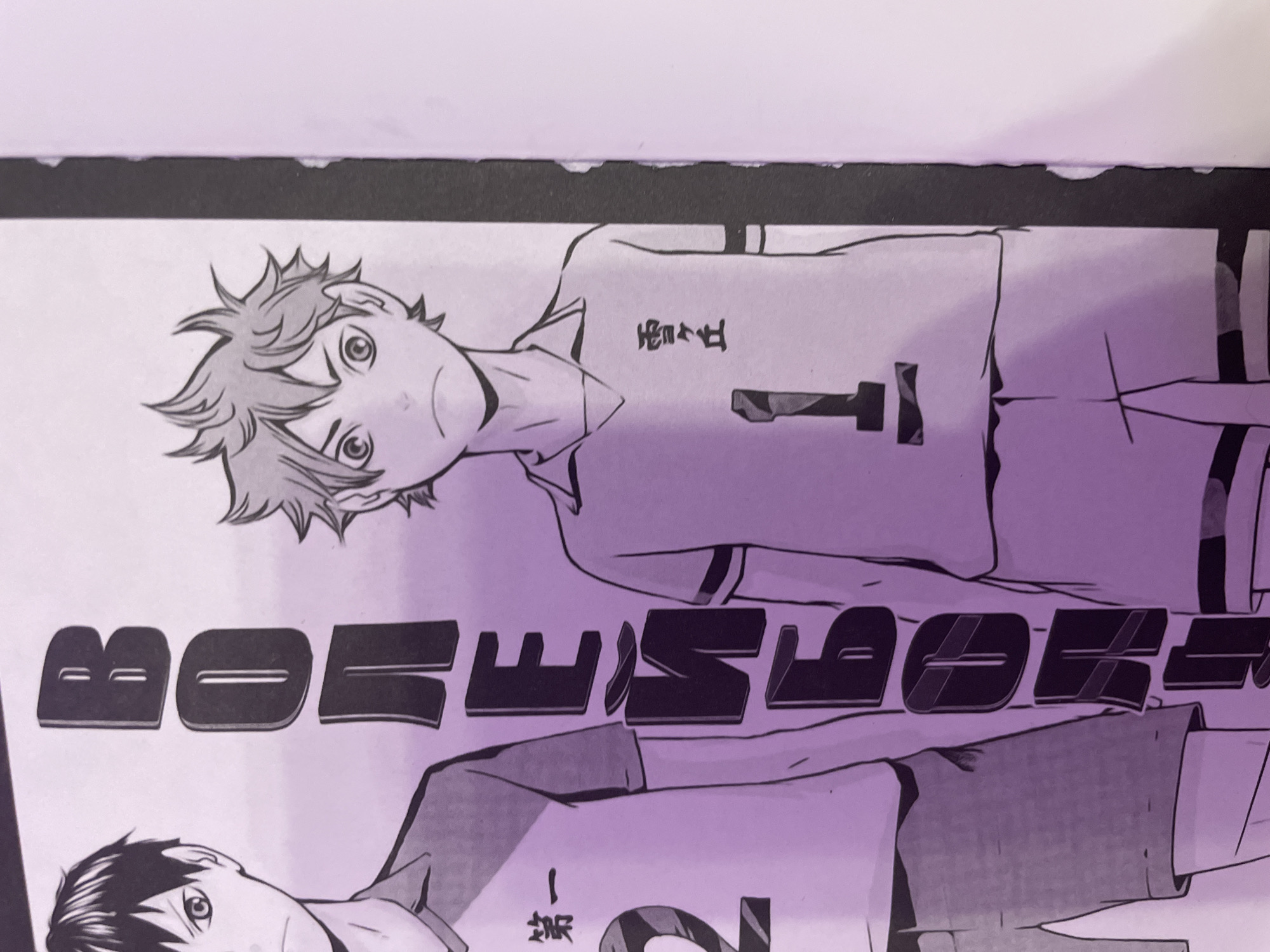 The image displays a close-up, angled shot of two anime-style male characters positioned next to each other. The character on the left has dark hair, sharp eyes, and is wearing a light-colored shirt with Japanese characters "第一" and the number "2" on it. The character on the right has spiky orange hair and is wearing a light-colored shirt with Japanese characters "雪ヶ丘" and the number "1" on it. Between the two characters, large, bold, three-dimensional black letters are vertically aligned, spelling out "ВОЛЕЙБОЛ" (Volleyball in Russian). The background is a plain, light-colored surface. The lighting appears to be artificial, casting a purple hue over the scene. This image depicts characters from the anime "Haikyuu!!", which is centered around the sport of volleyball. The presence of the Russian word for "Volleyball" suggests a potential connection to a Russian publication or fan art. There is no indication of the city of Irinovka, Russia, within the image itself.