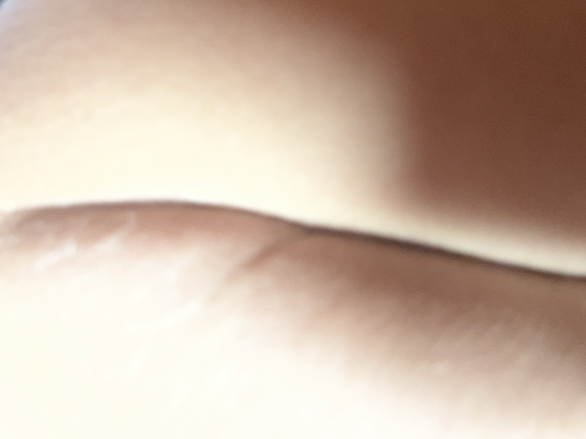 The image is a close-up, abstract shot of human skin, likely a portion of a buttocks. The lighting is bright and diffused, creating soft shadows and highlights that emphasize the texture and curves of the skin. There are no discernible objects, background elements, or environmental features visible. The location in Chaikovsky, Russia, cannot be determined from the visual information provided in the image.