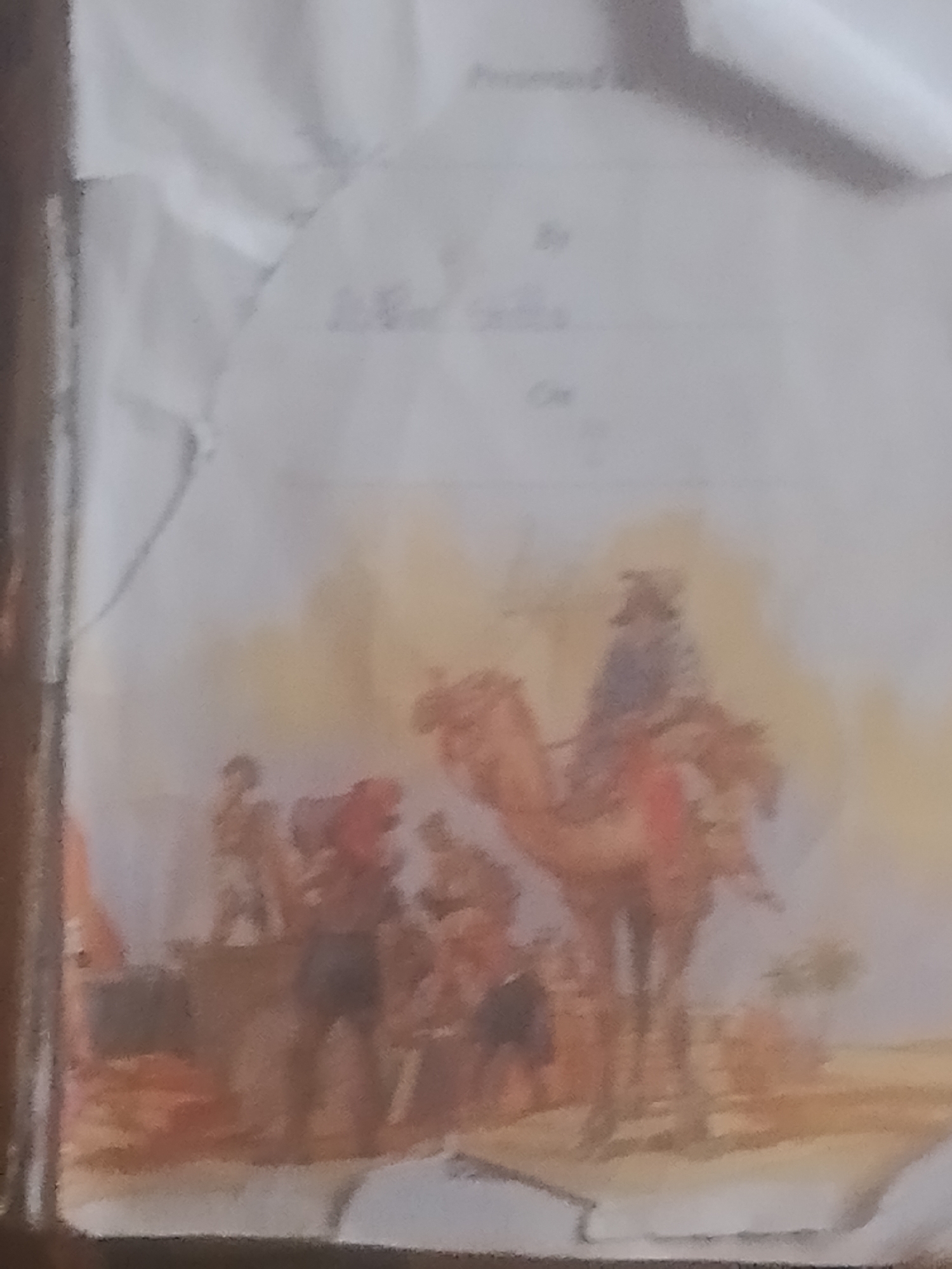 The image depicts a watercolor painting of a desert scene with a caravan. In the foreground, a man on a camel is visible, along with other figures and camels in the background. The landscape is arid and sandy, with hints of vegetation. The overall impression is one of a journey through a desert environment. The painting appears to be a historical or cultural representation of a caravan, possibly in a region like Jauro Yinu, Nigeria, which is known for its desert climate and historical trade routes.
