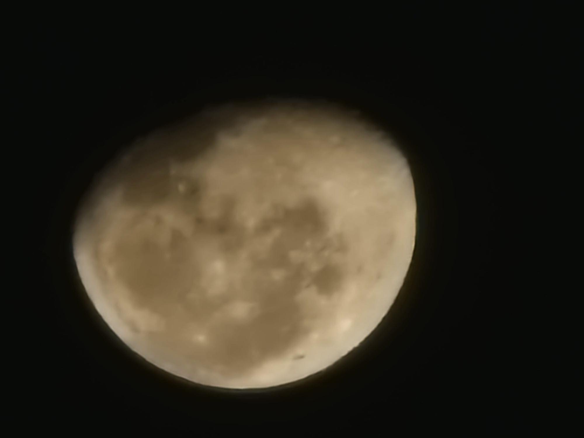 The image is a close-up of the moon against a black sky. The moon is partially illuminated, showing its surface details such as craters and plains. The lighting suggests it is not a full moon. There are no discernible city or geographical features, and therefore no specific location in Shymkent, Kazakhstan can be identified. The image does not contain any people, objects, or actions typically associated with a city scene.
